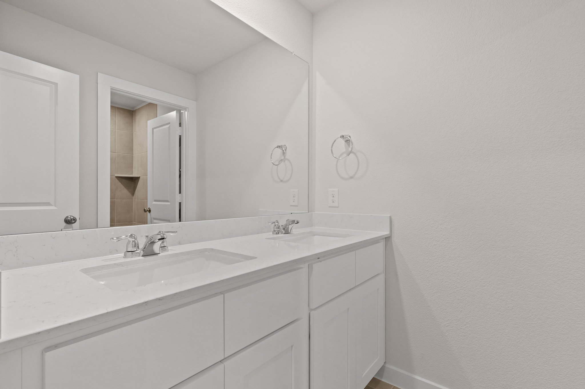 A bathroom with white cabinets.