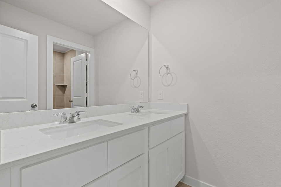 A bathroom with white cabinets.