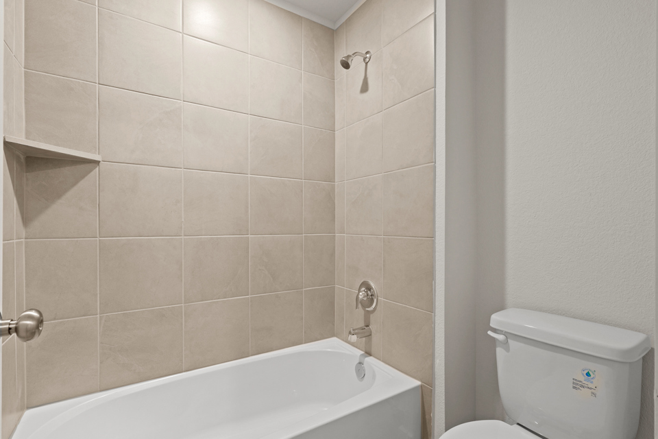 A bathroom with a bathtub and toilet.