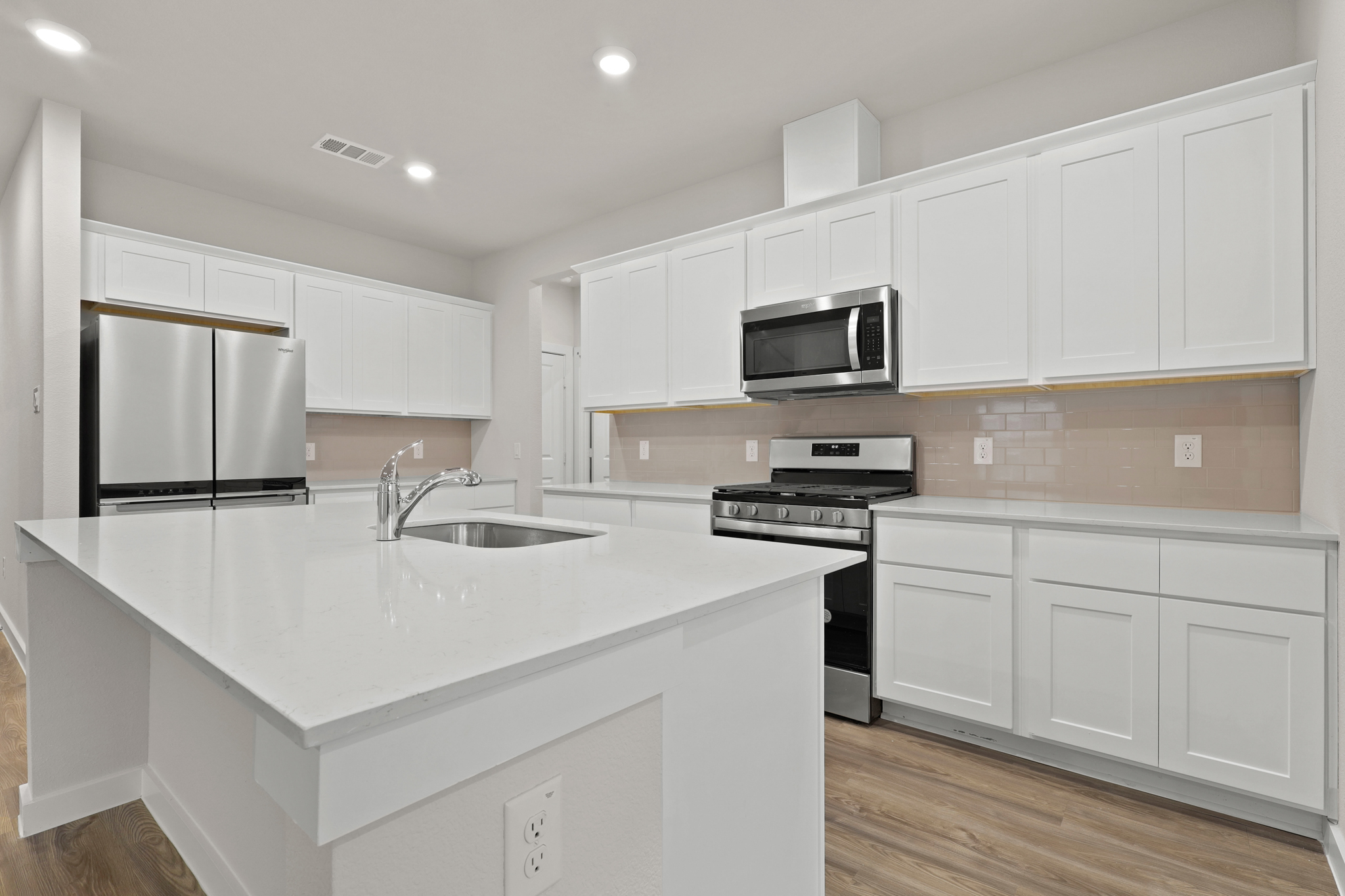 A kitchen with white cabinets.