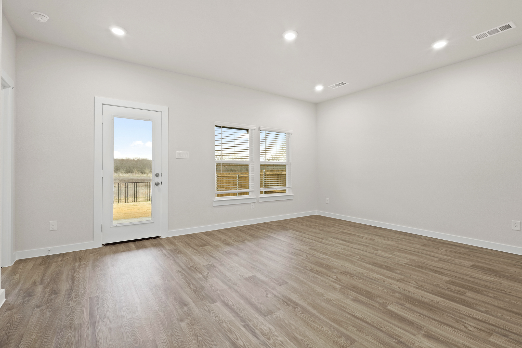 A room with a wood floor and windows.