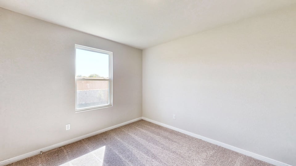 A room with a window and carpet.