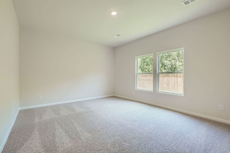A room with a carpet and windows.