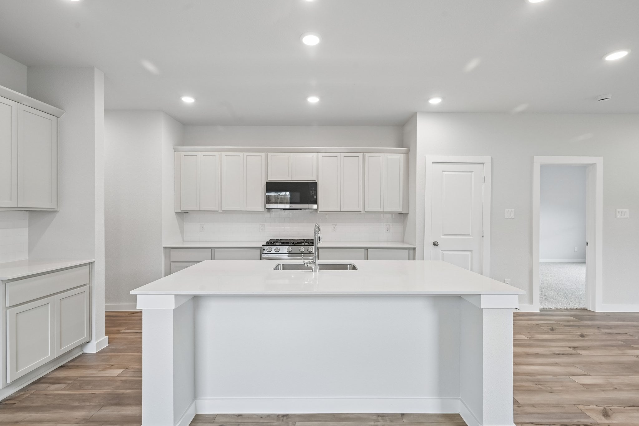 A kitchen with white cabinets.