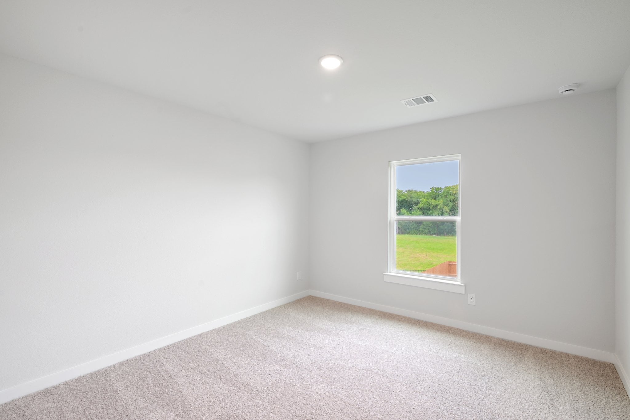 A room with a window and a green field.