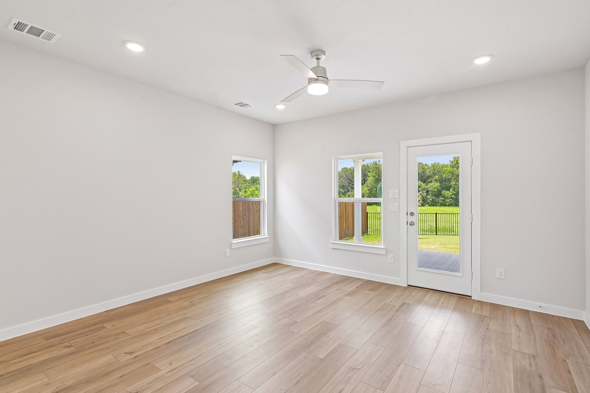 A room with a wood floor and a wood floor with a ceiling fan and a wood floor with.