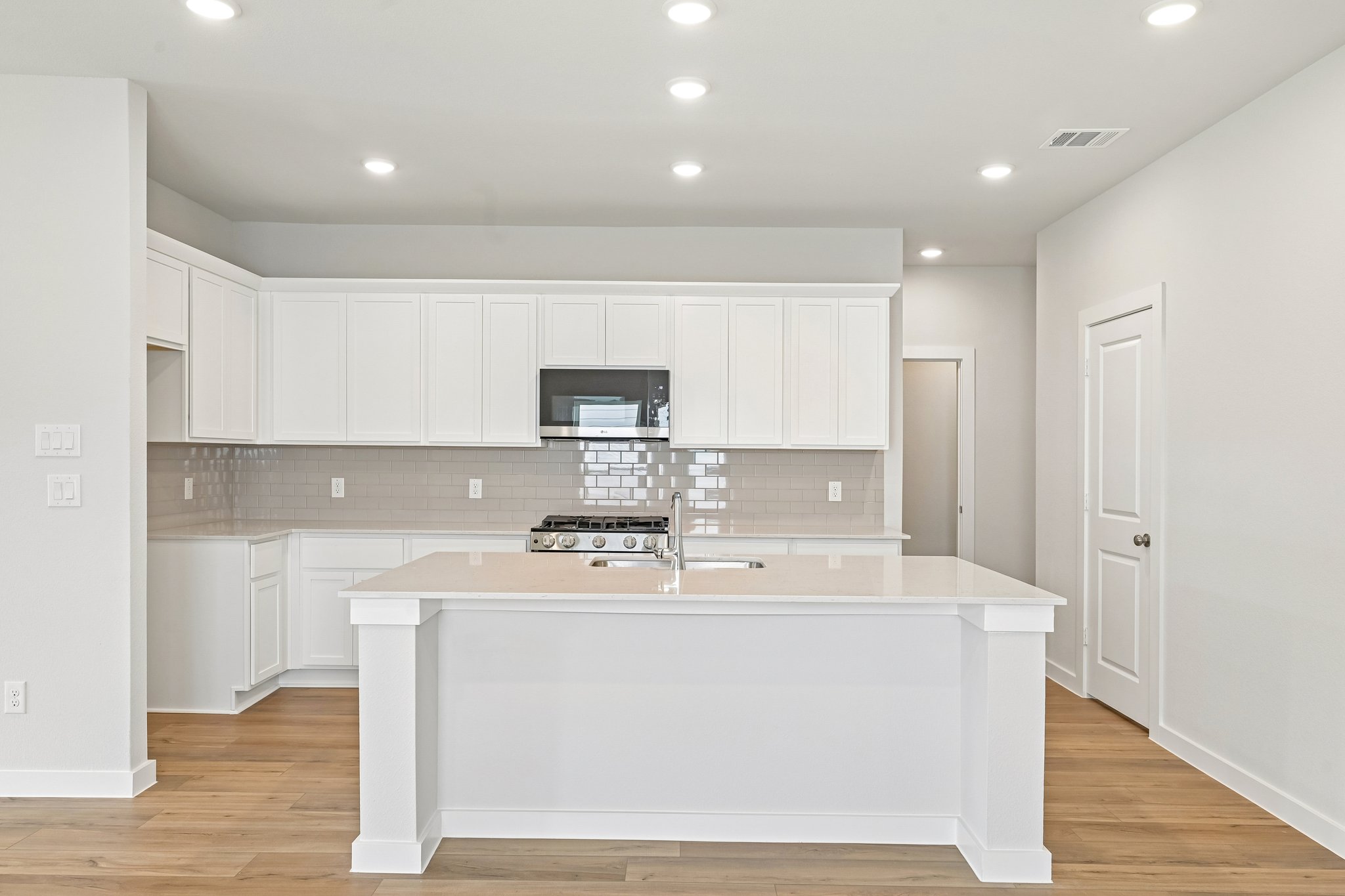 A kitchen with white cabinets.