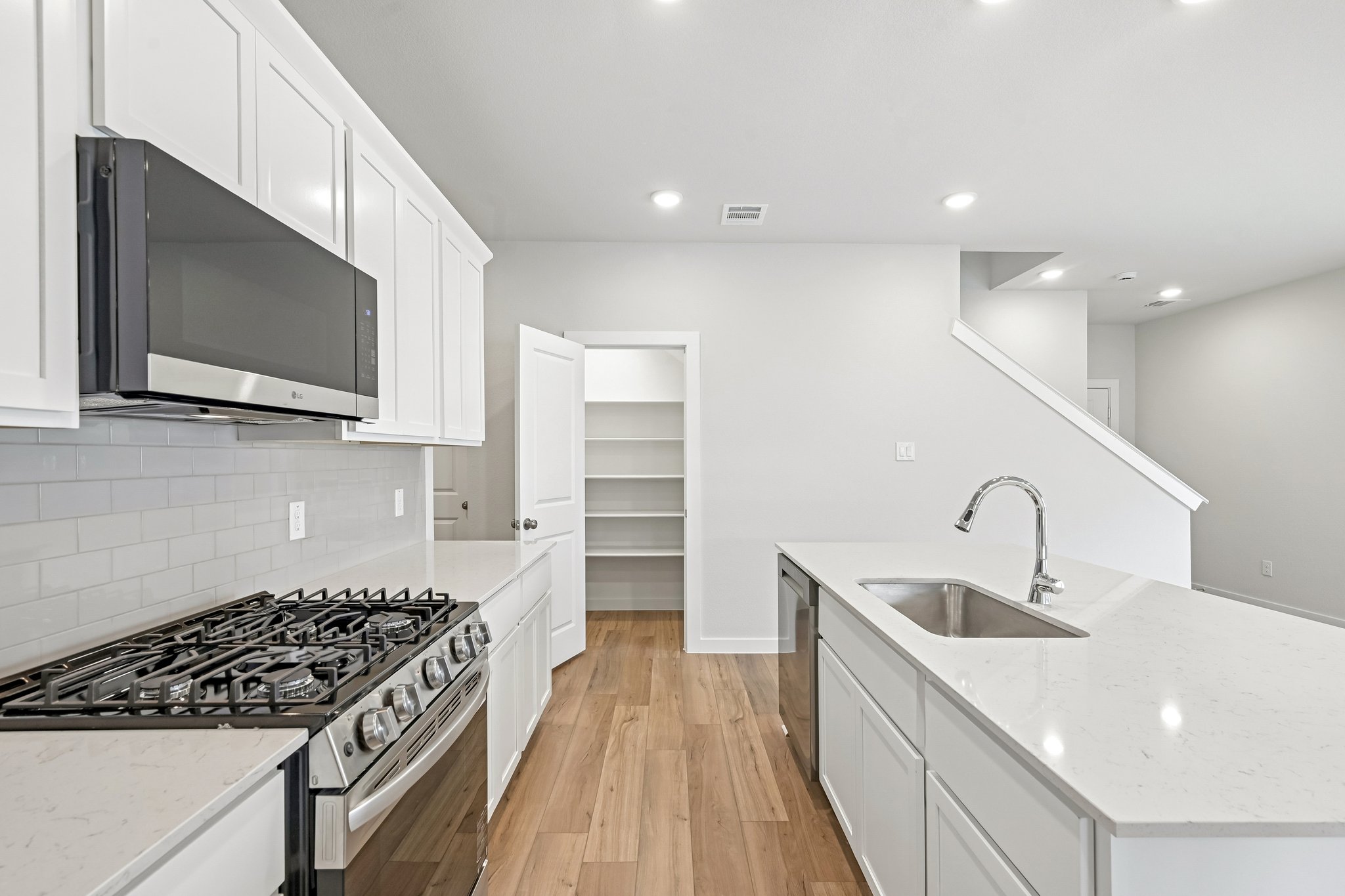 A kitchen with white cabinets.
