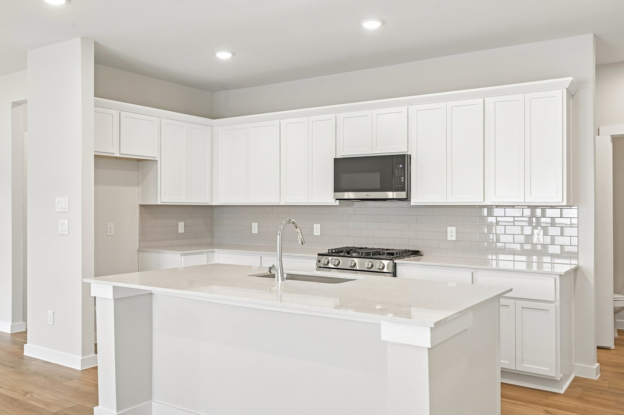 A kitchen with white cabinets.