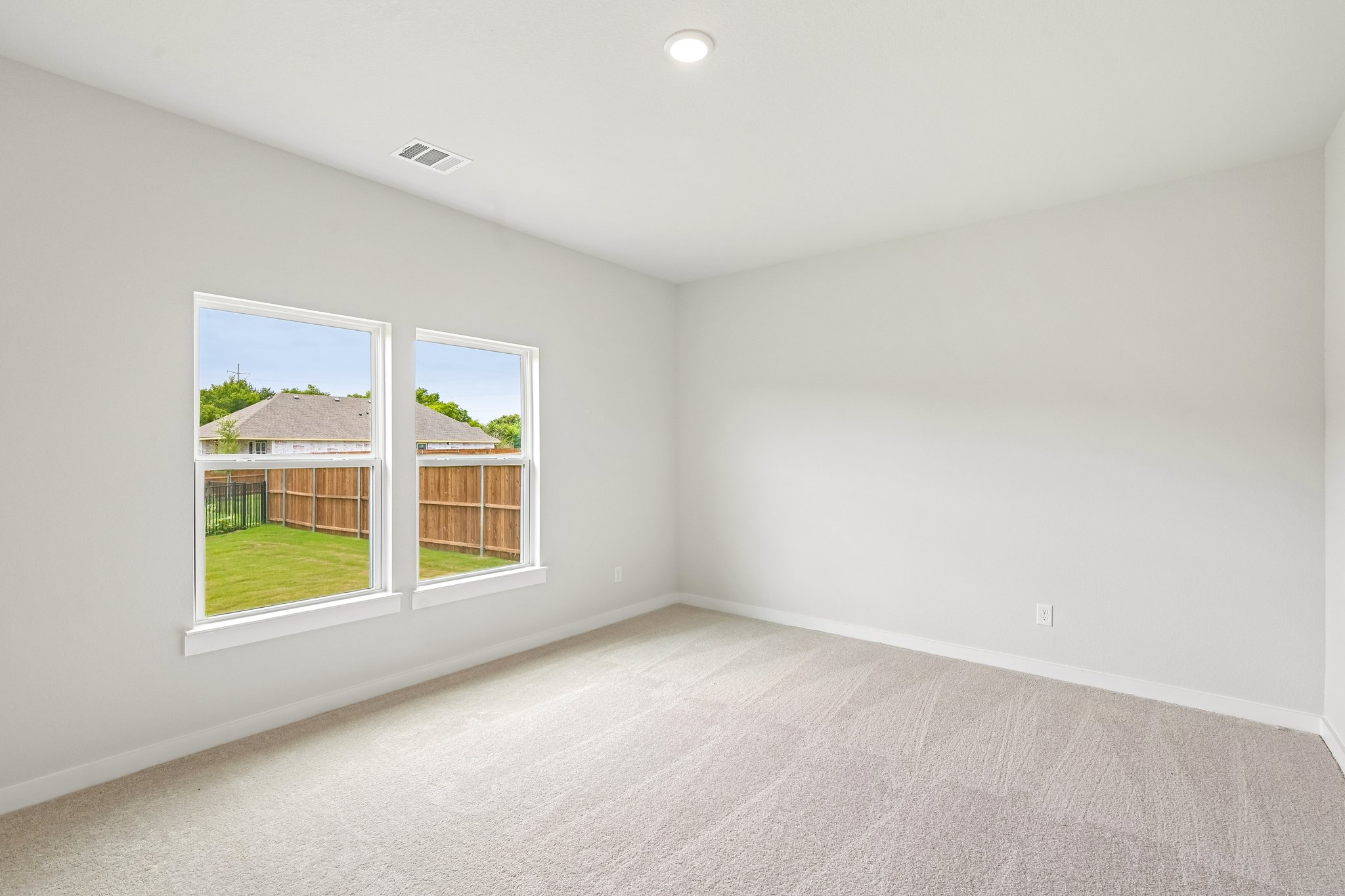 A room with a window and a green field.