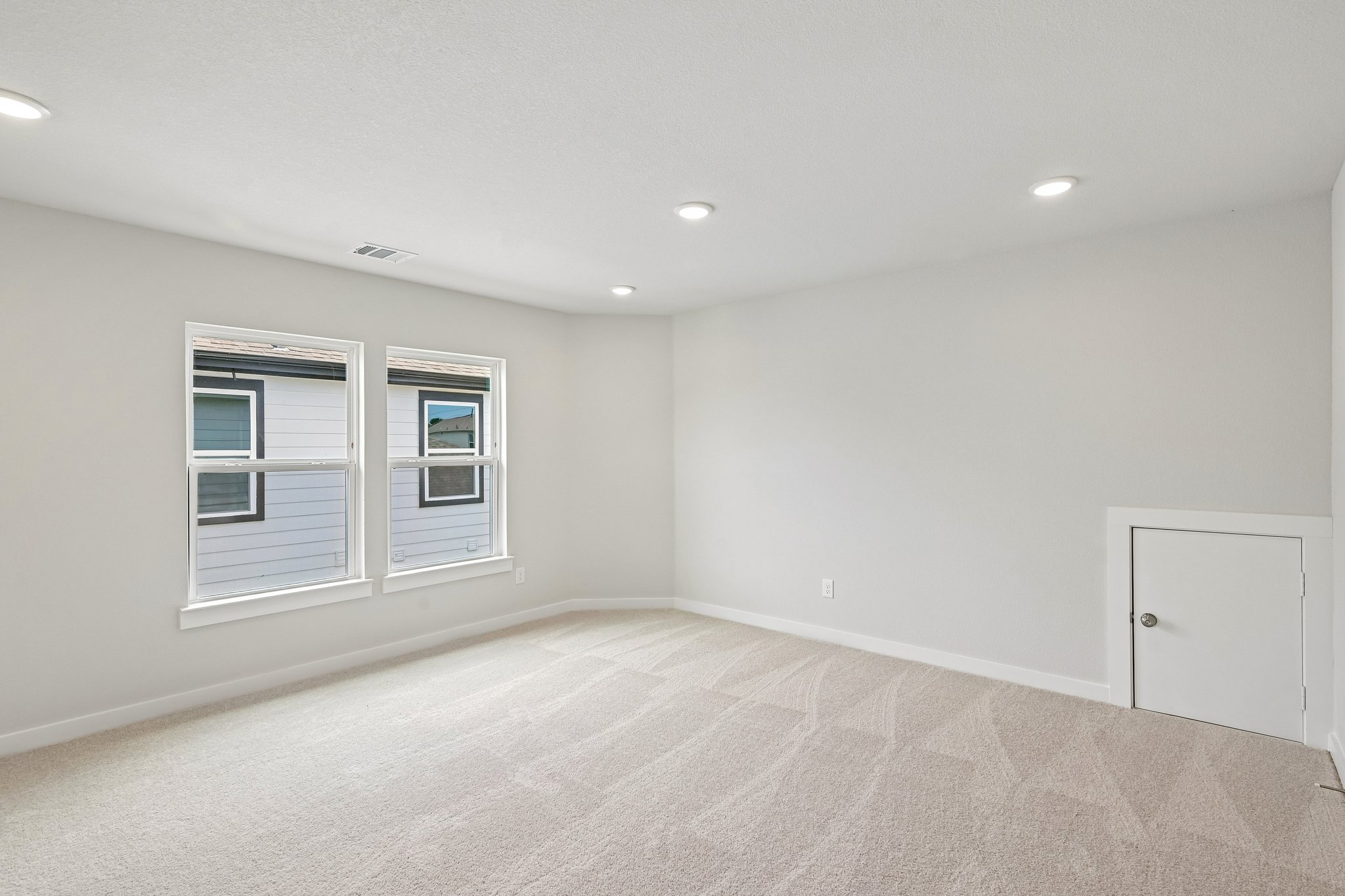 A room with a carpet and windows.