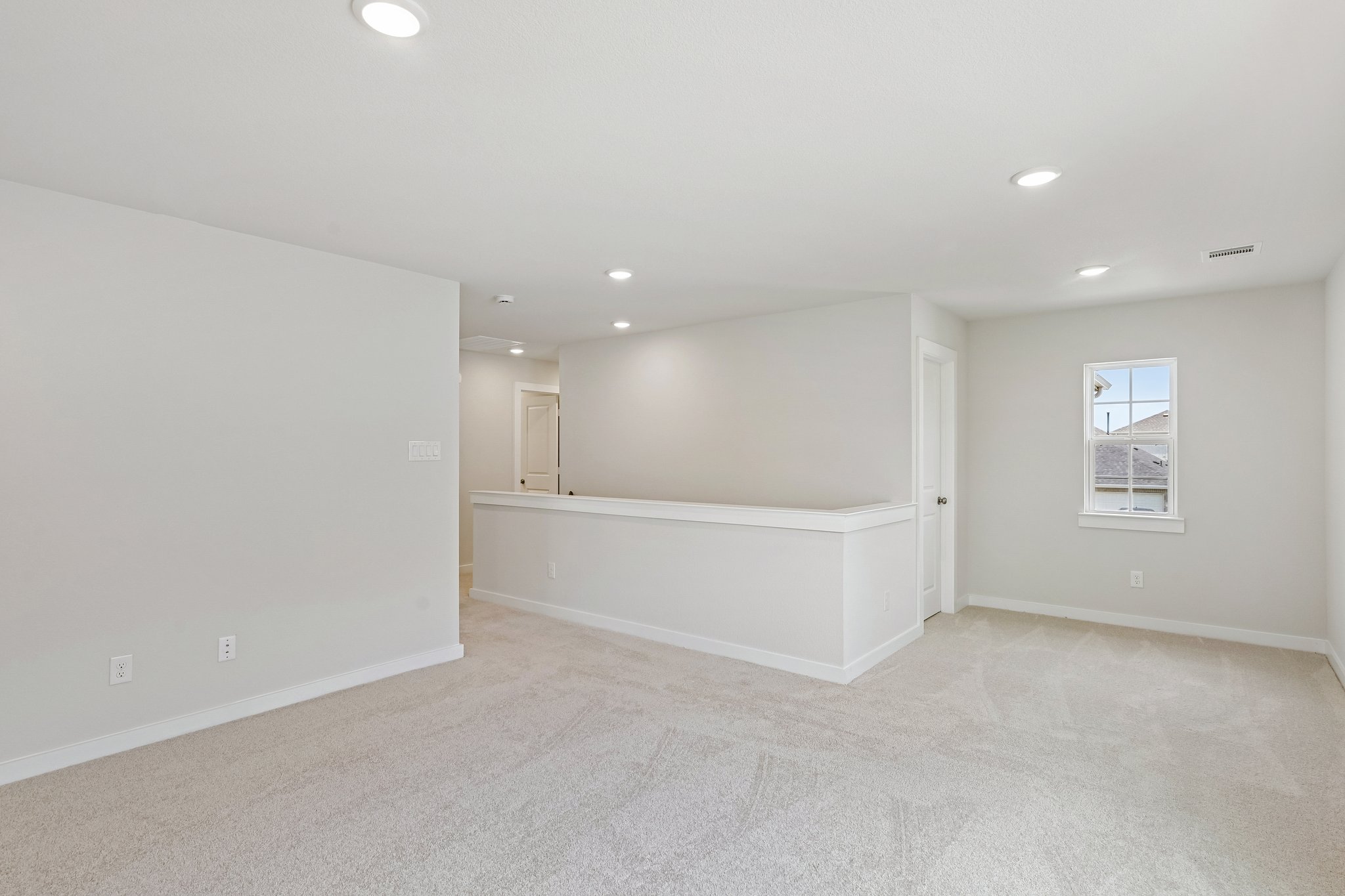 A room with a bed and a white wall.