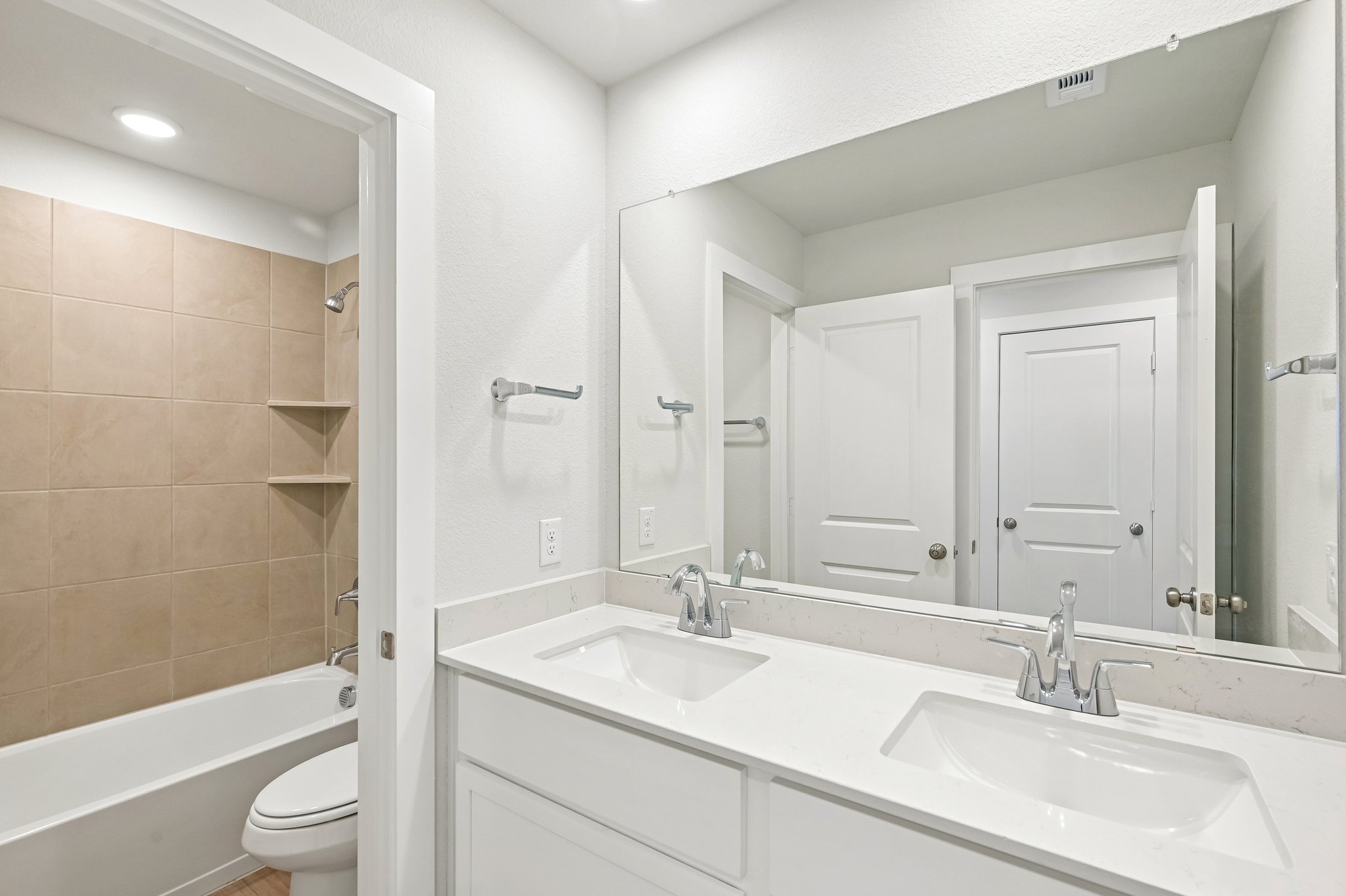 A bathroom with a large mirror.