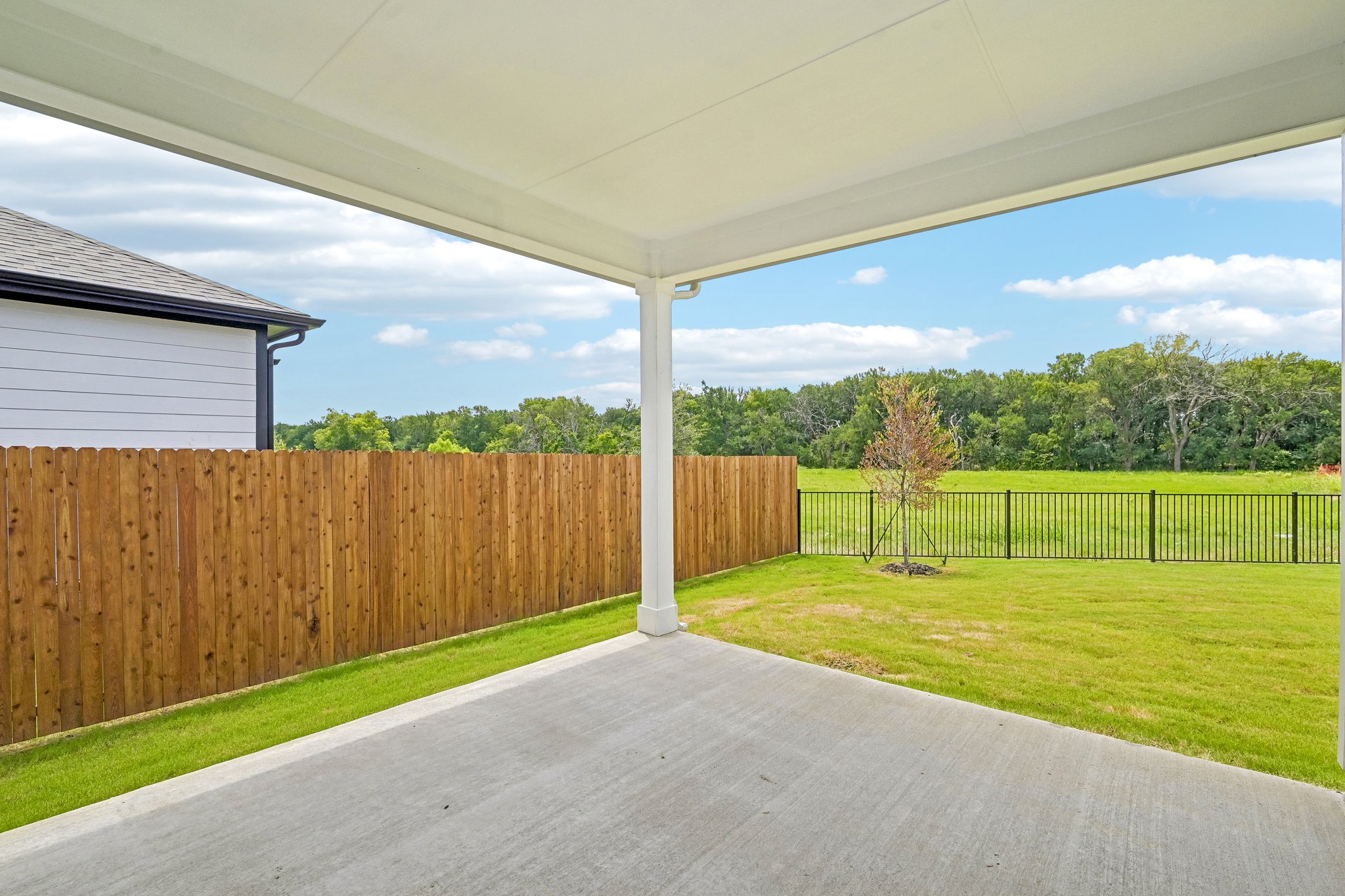 A fenced in yard with a wood fence and a wood fence.