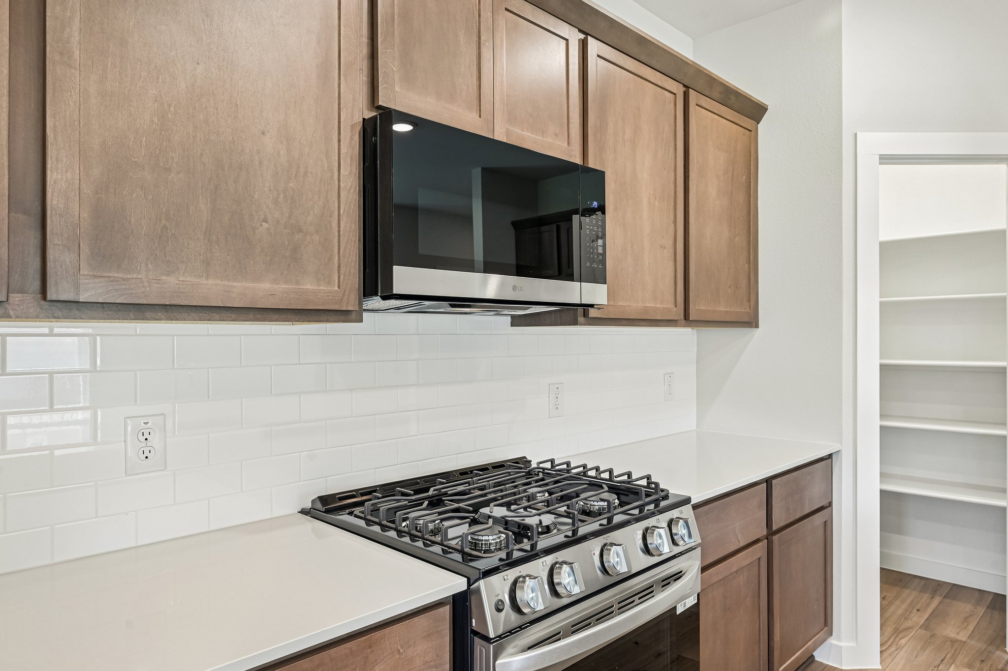 A kitchen with a stove and microwave.