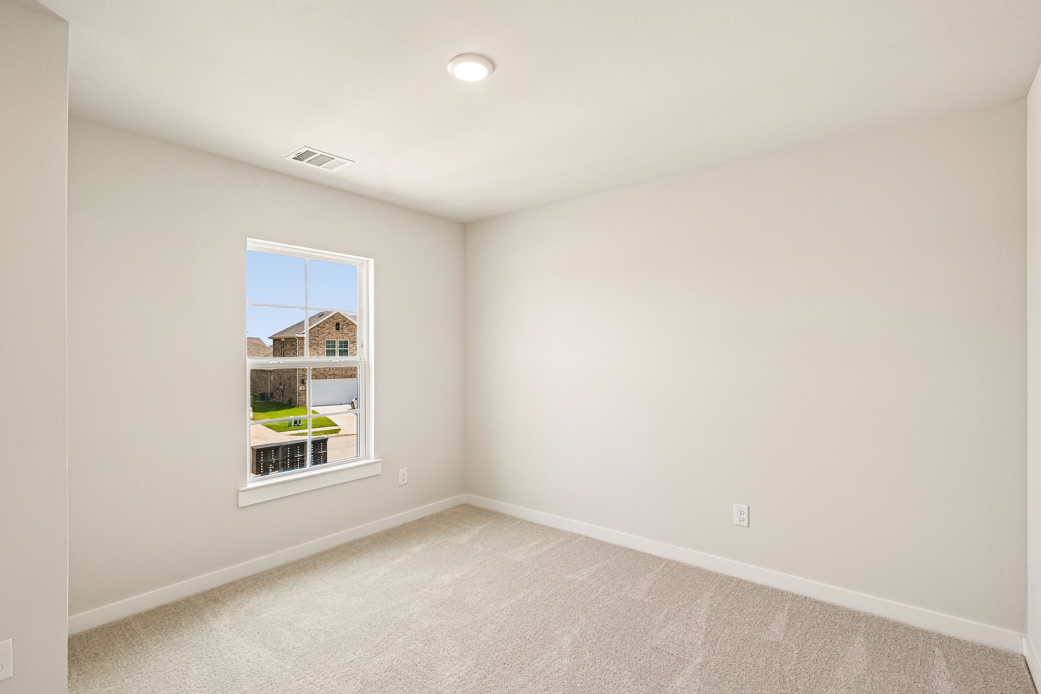 A room with a window and a carpet.