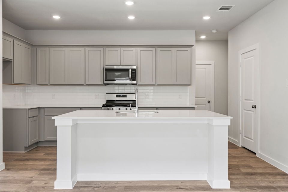 A kitchen with white cabinets.