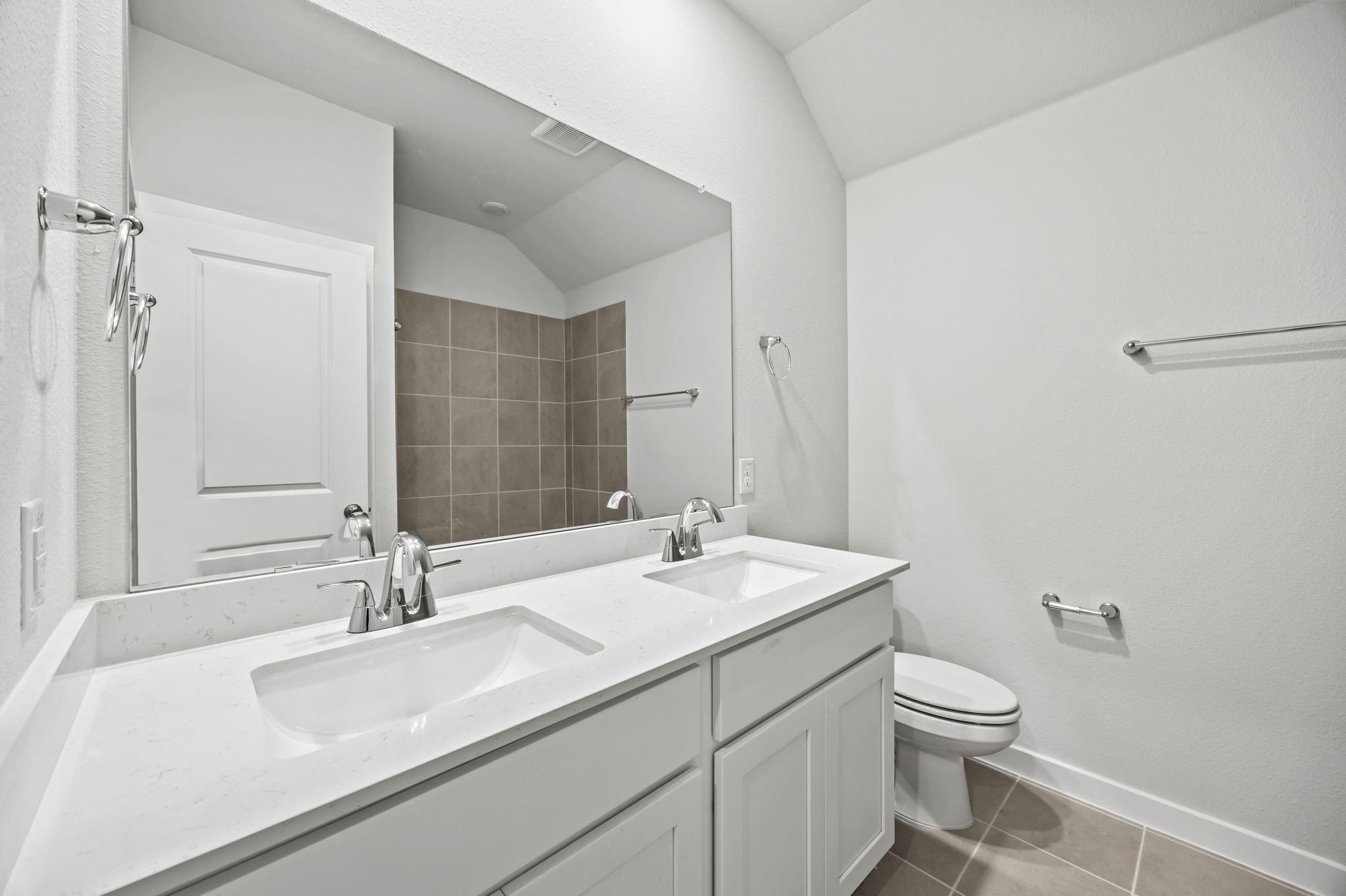 A bathroom with a large mirror.