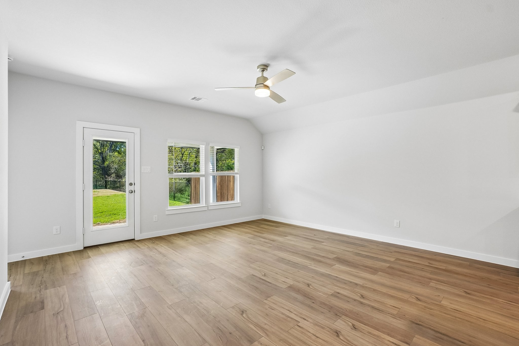 A room with a wood floor and a ceiling fan.