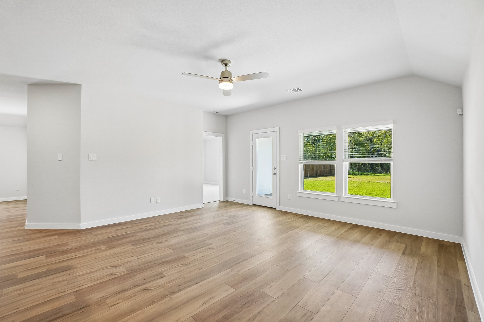 A room with a wood floor and a ceiling fan.
