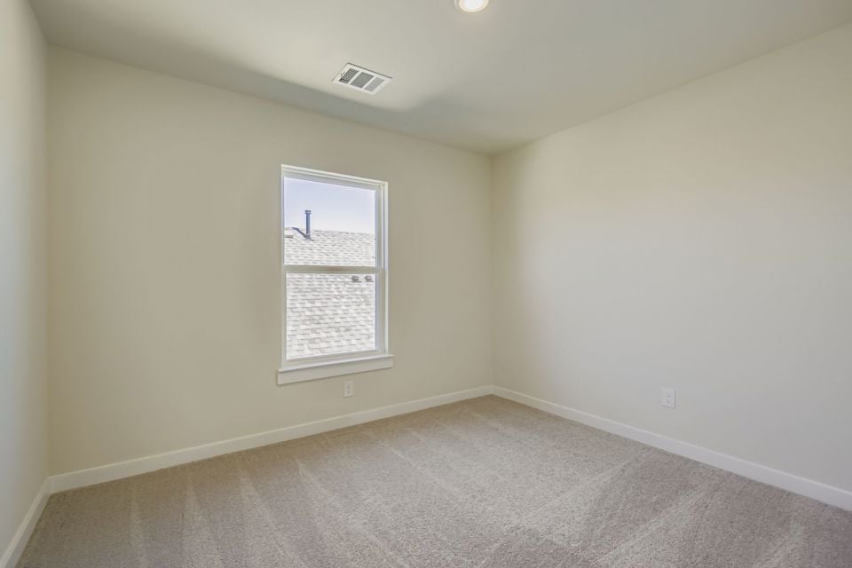 A room with a window and a carpet.