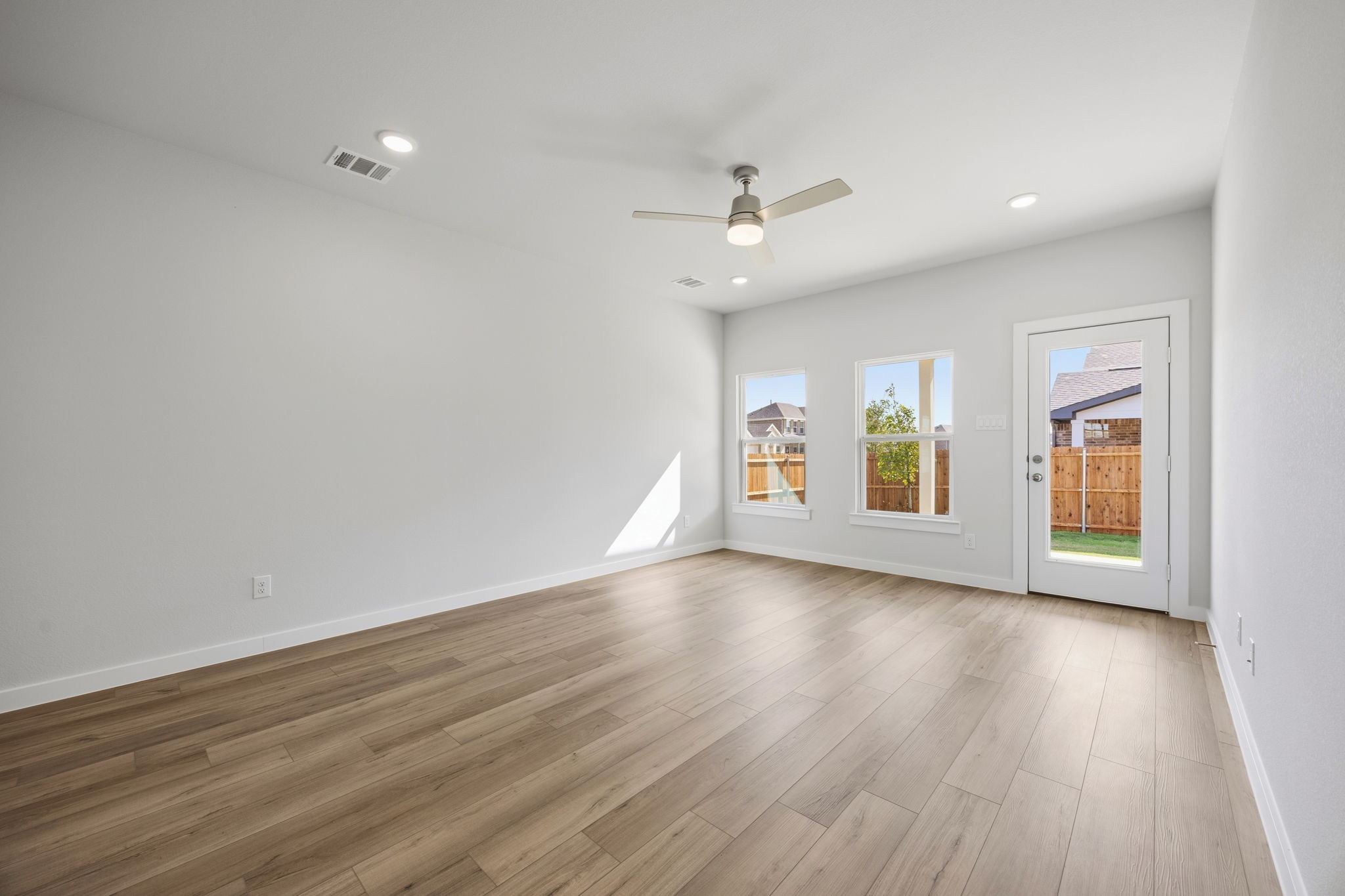 A room with a wood floor and a ceiling fan.