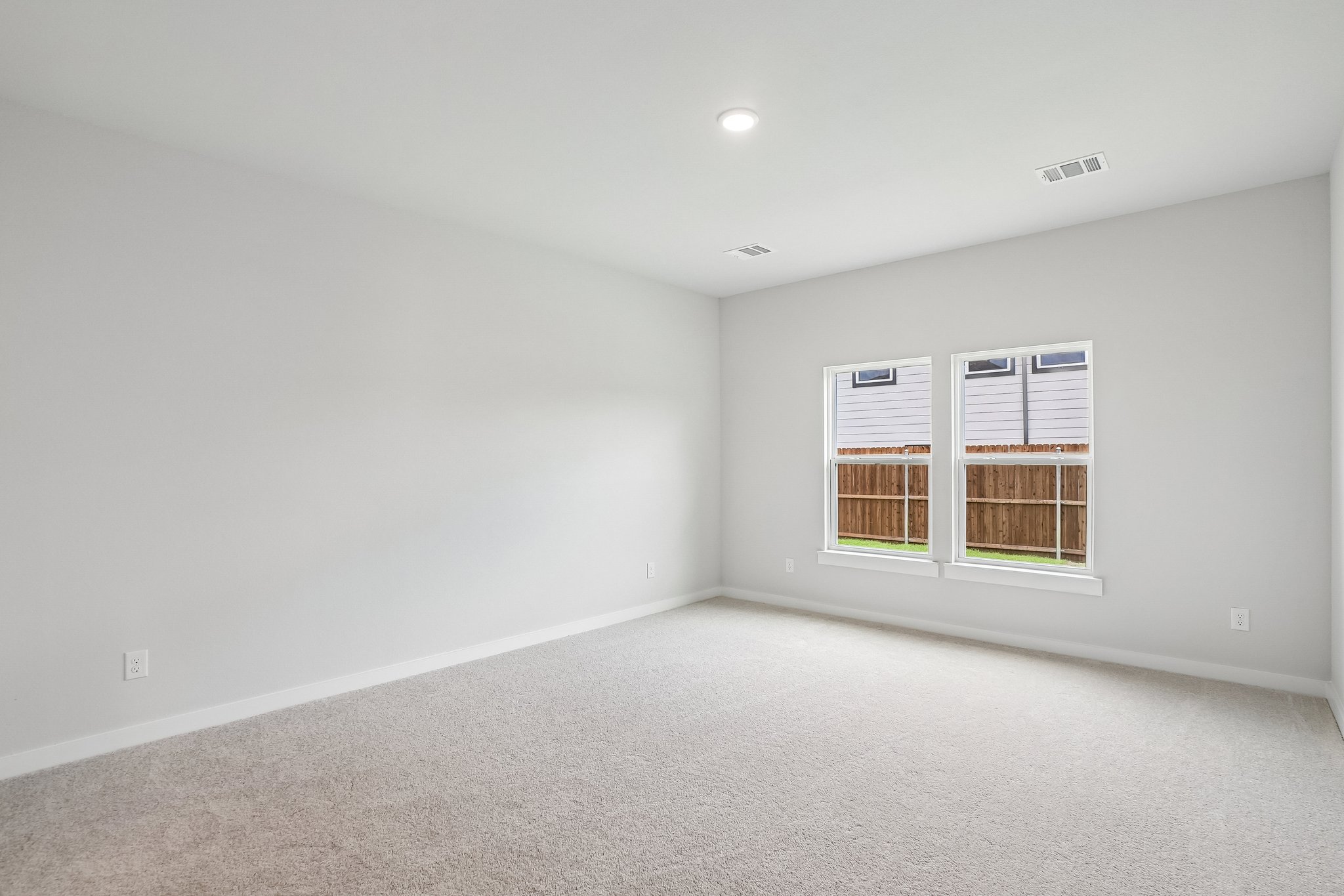 A room with a window and a white wall.
