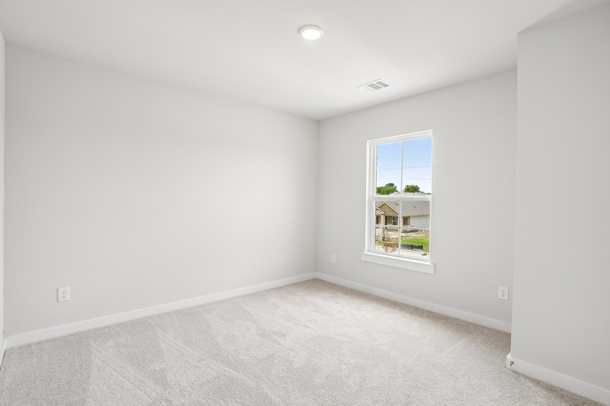 A room with a window and a carpet.