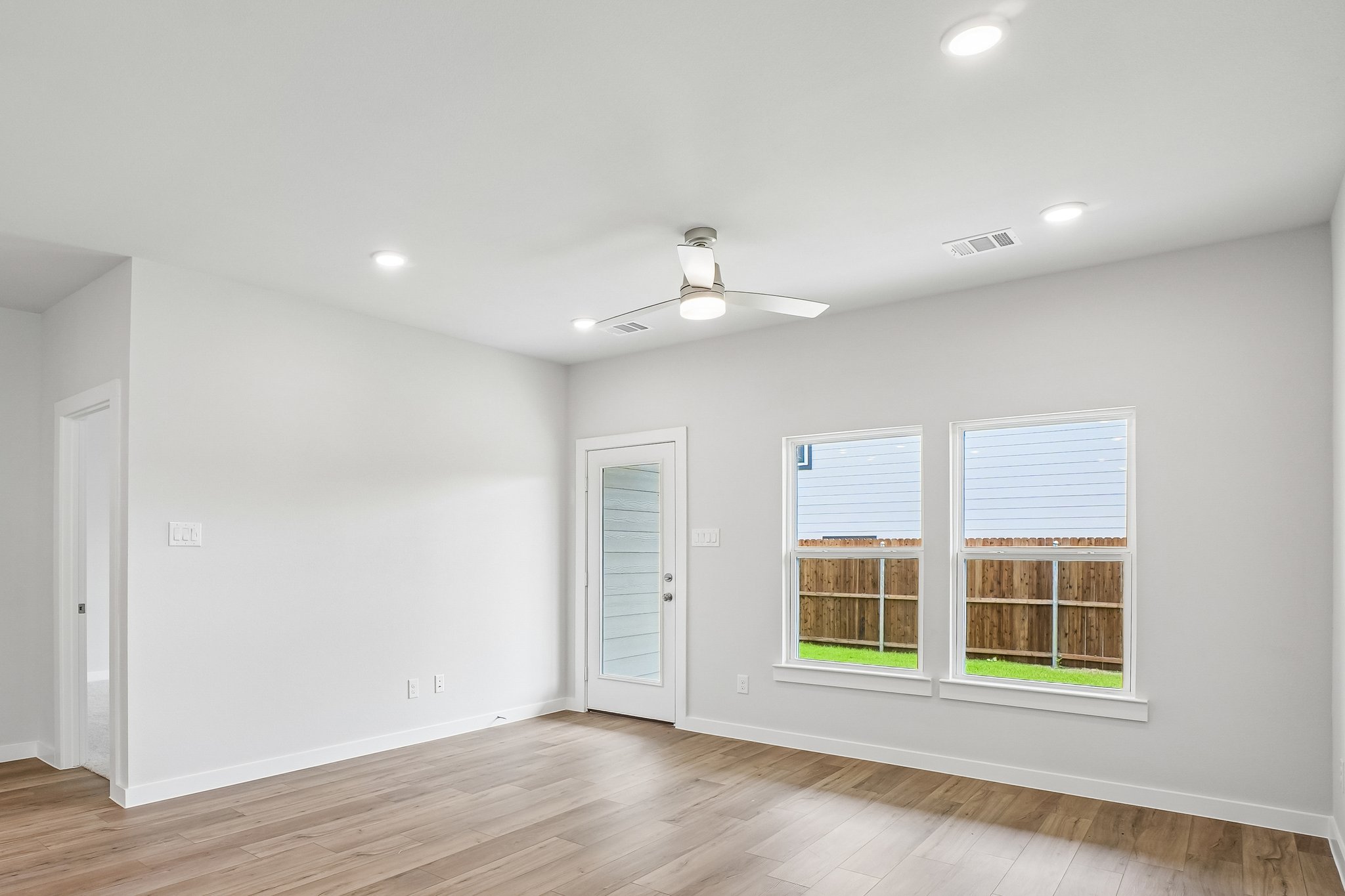 A room with a wood floor and windows.