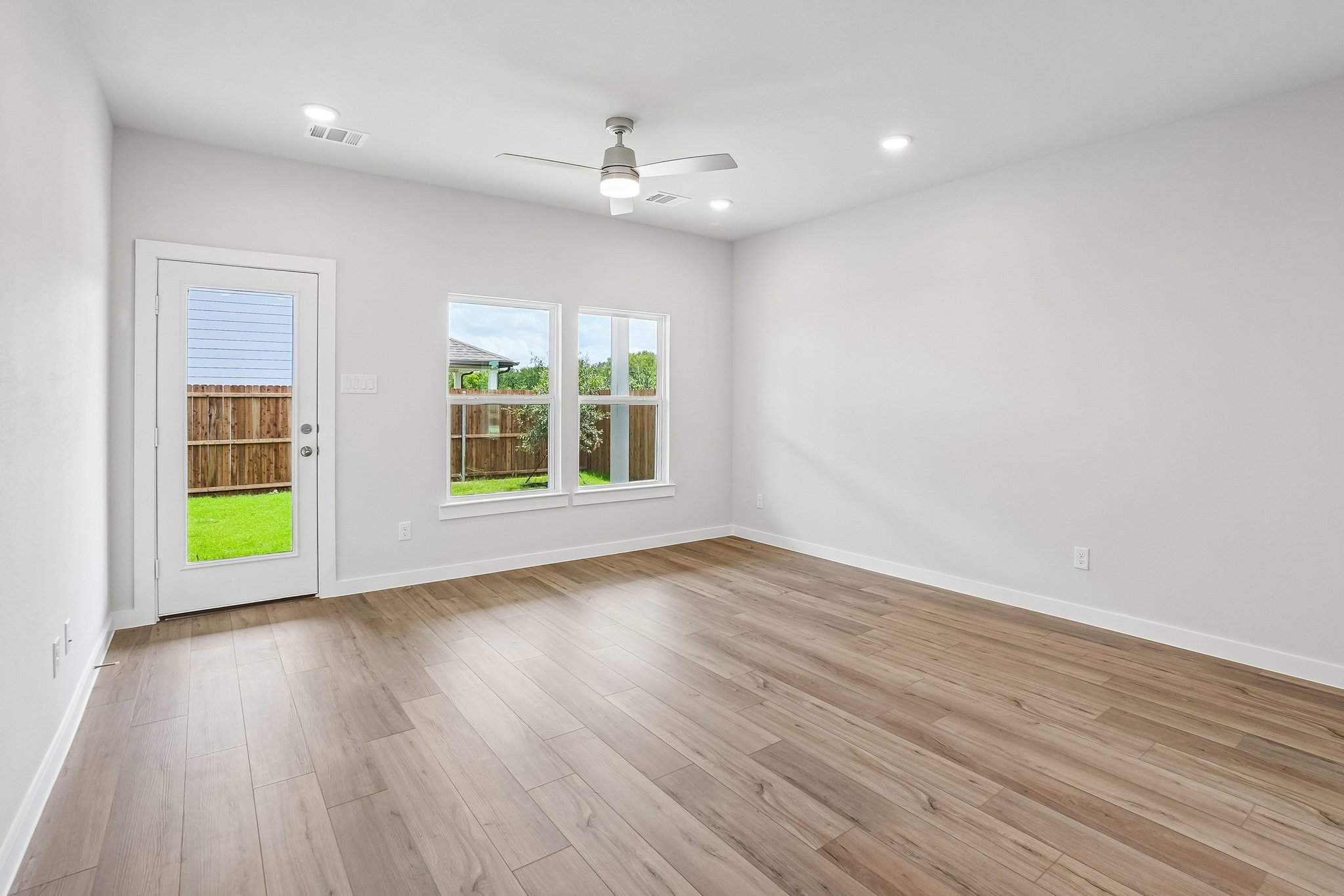 A room with a wood floor and windows.