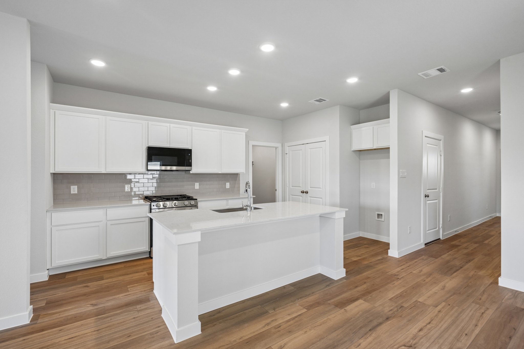 A kitchen with white cabinets.