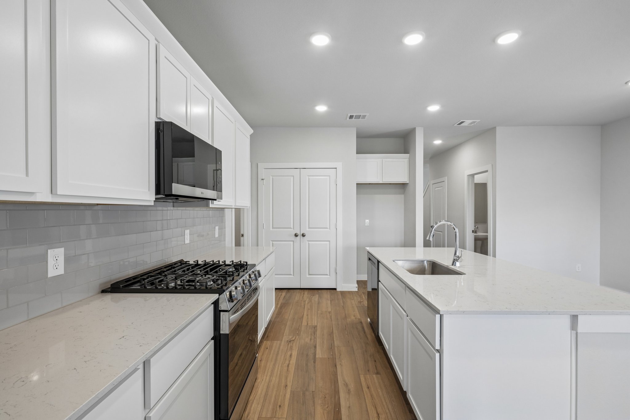 A kitchen with white cabinets.