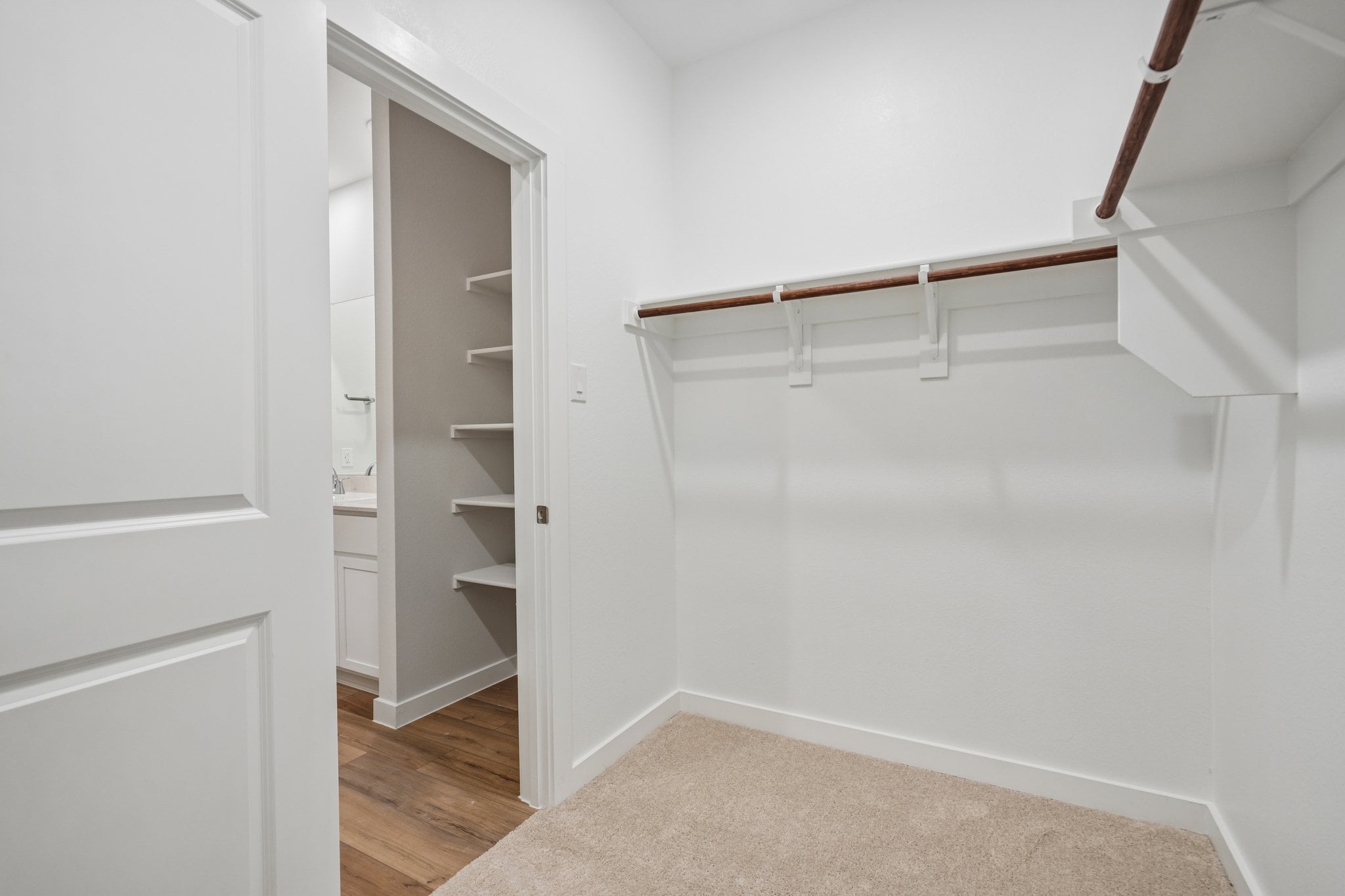 A white room with a white wall and a wood shelf.