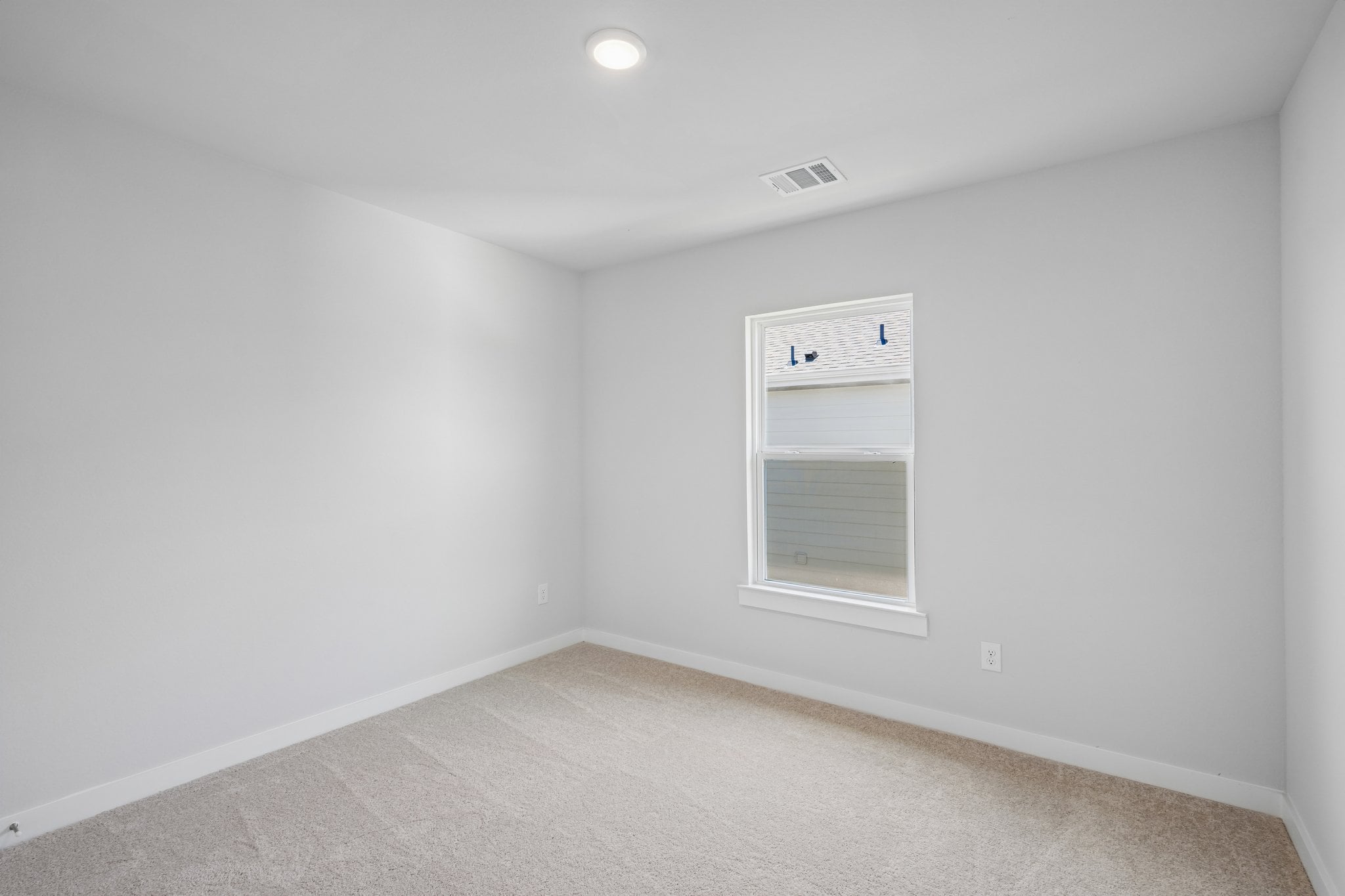 A room with a window and a carpet.