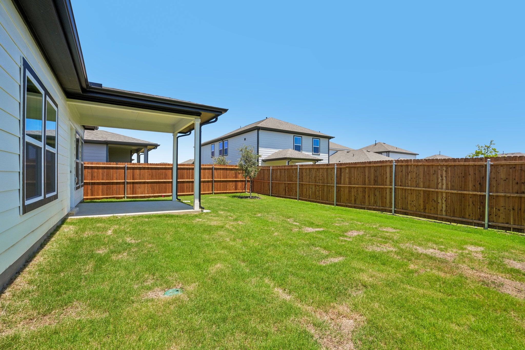 A fenced in yard with a house in the background.