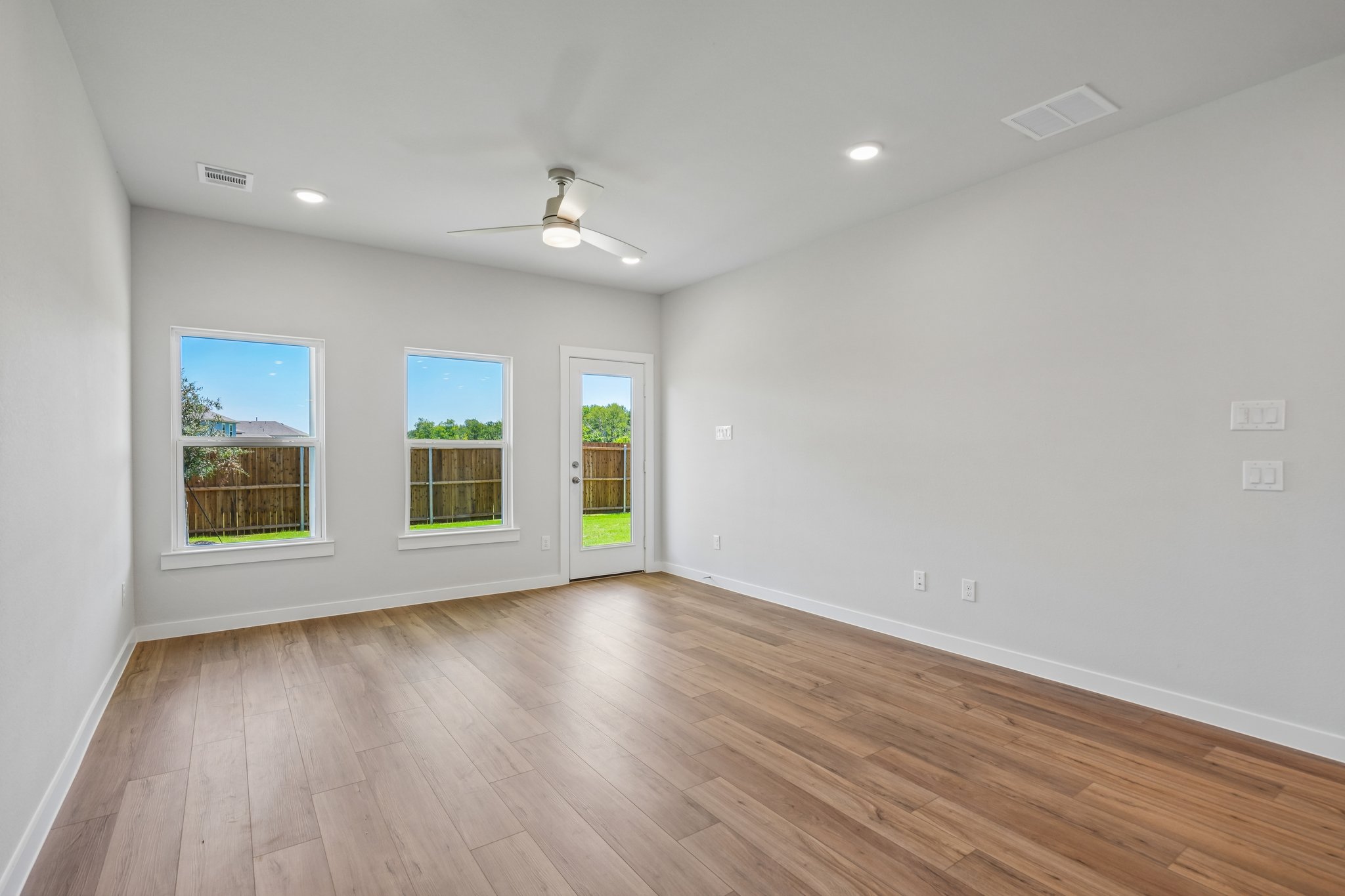 A room with a wood floor and windows.