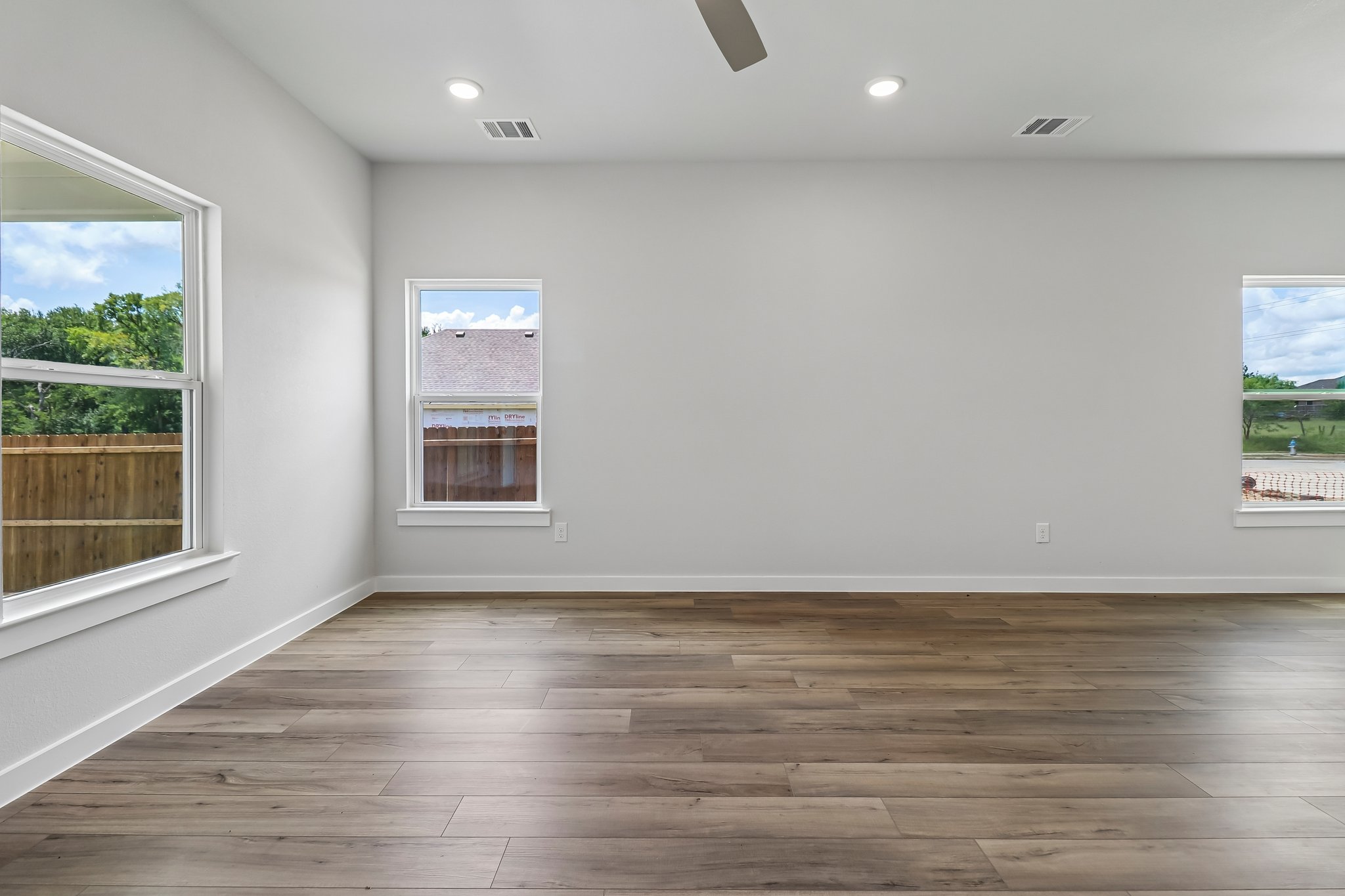 A room with a wood floor and a wood floor with a window.