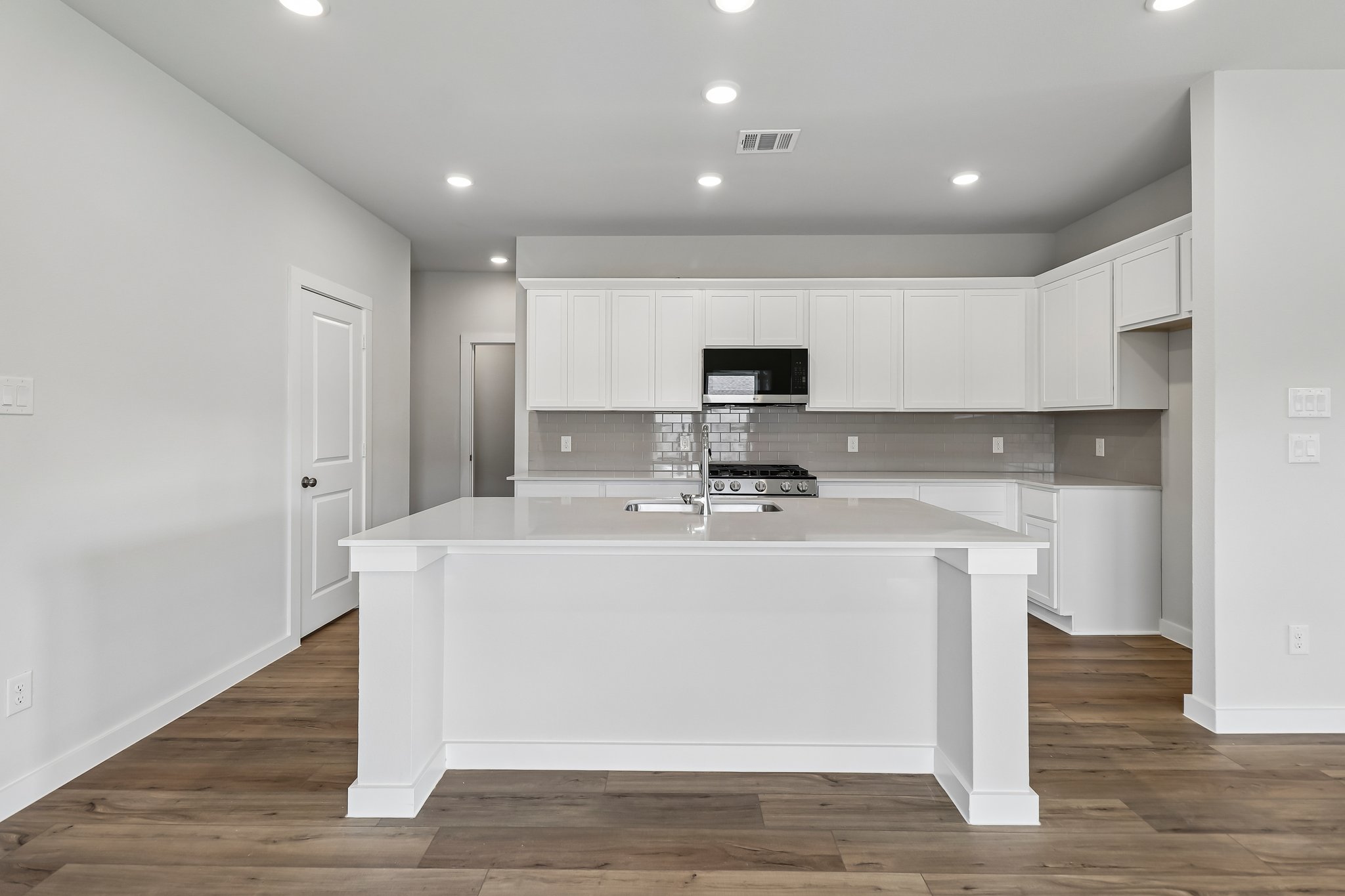 A kitchen with white cabinets.