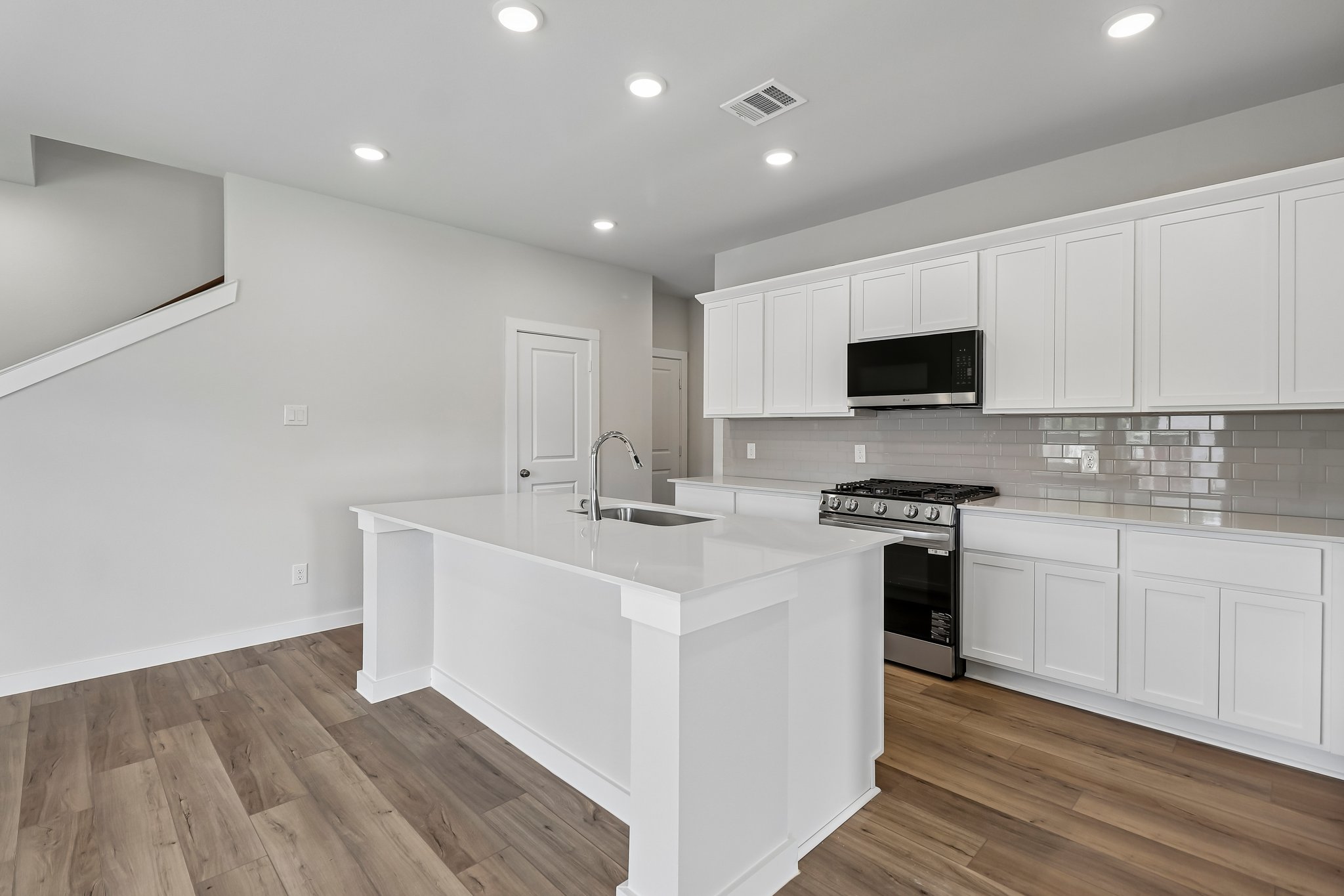 A kitchen with white cabinets.