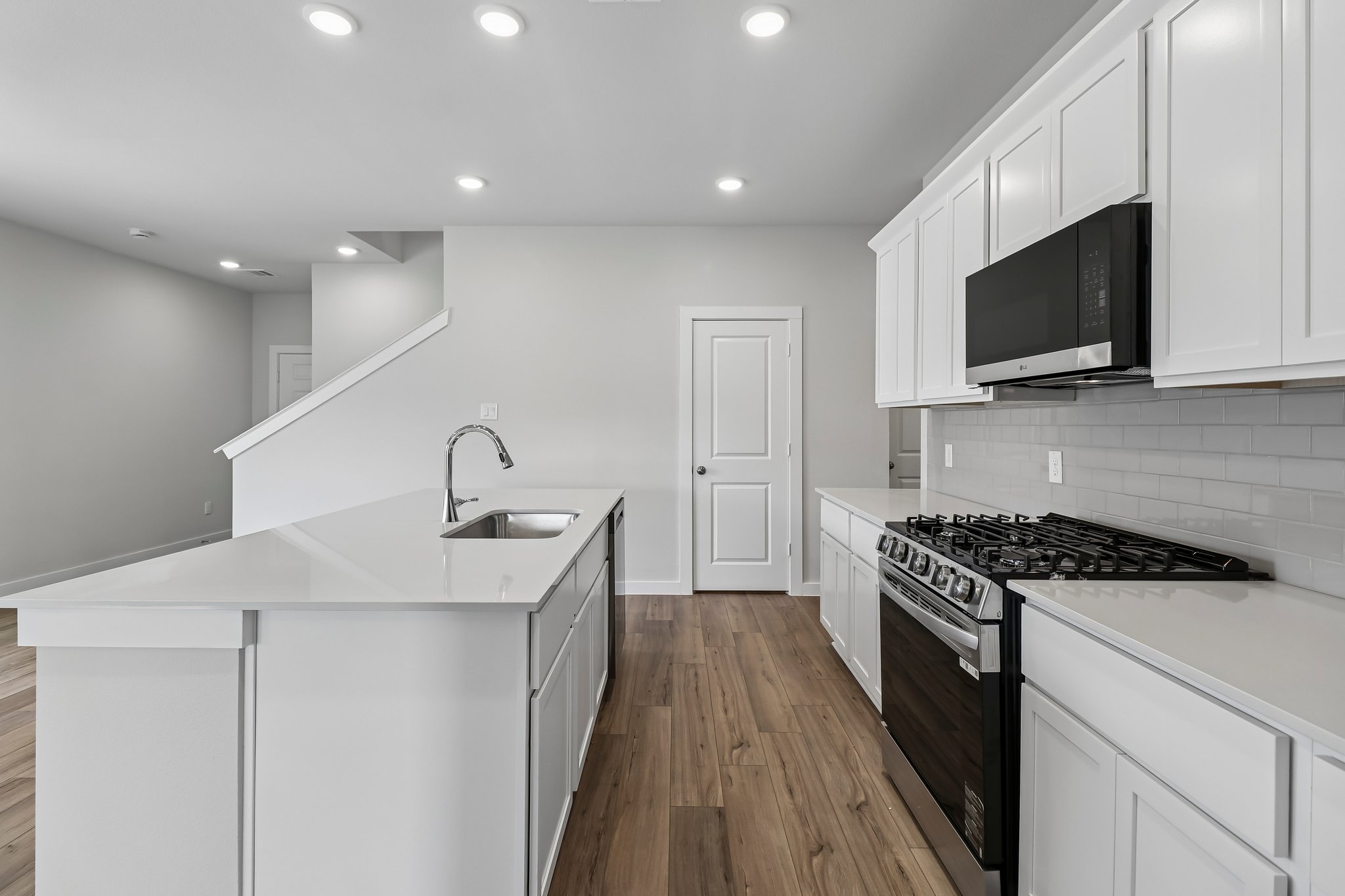 A kitchen with white cabinets.