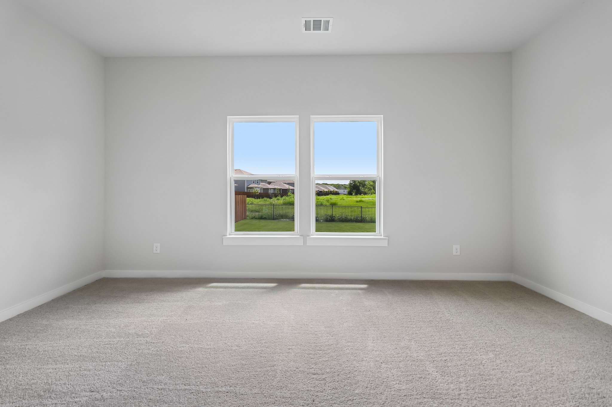 A room with a window and a view of the grass.