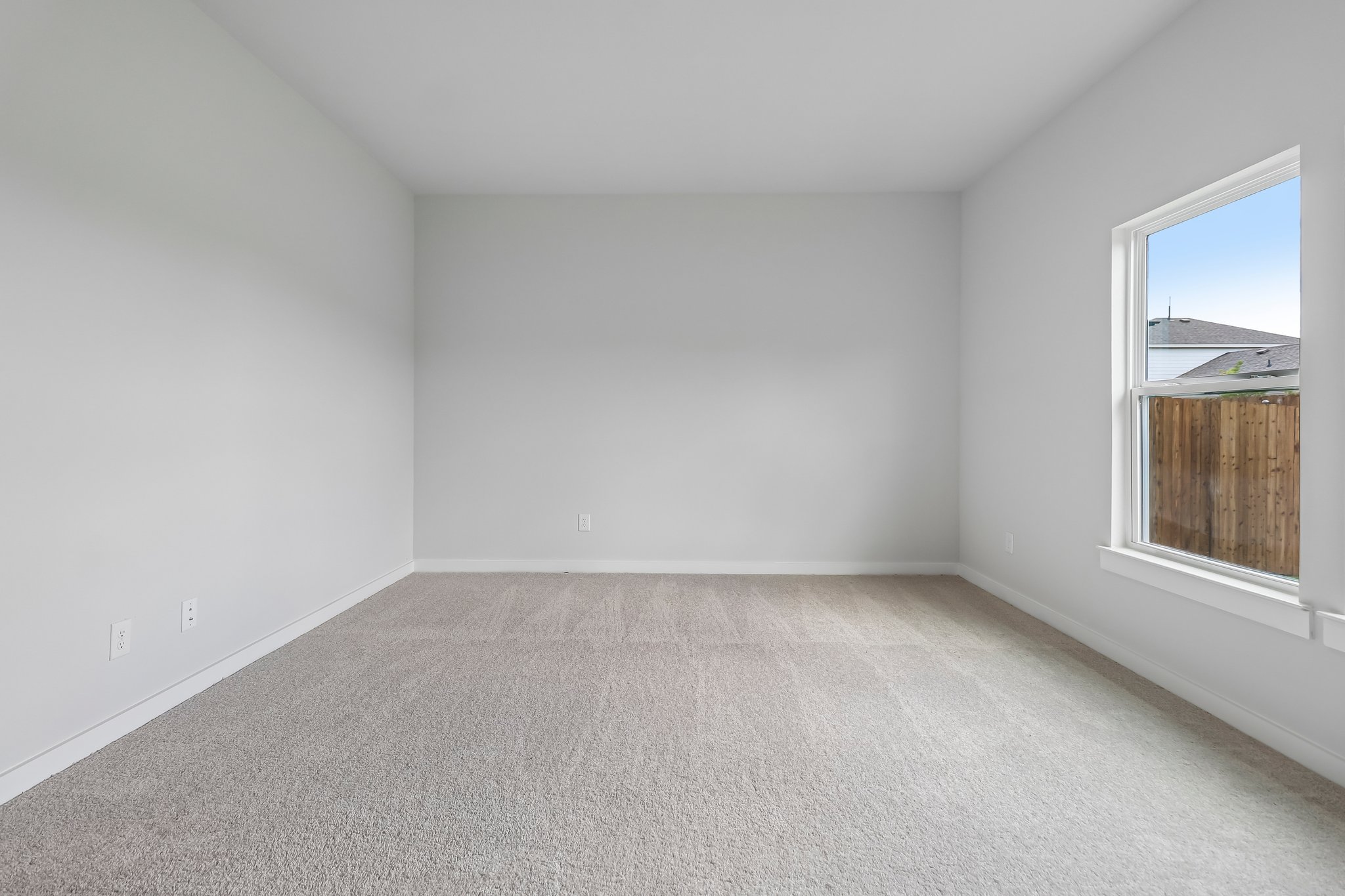 A room with a window and a carpet.
