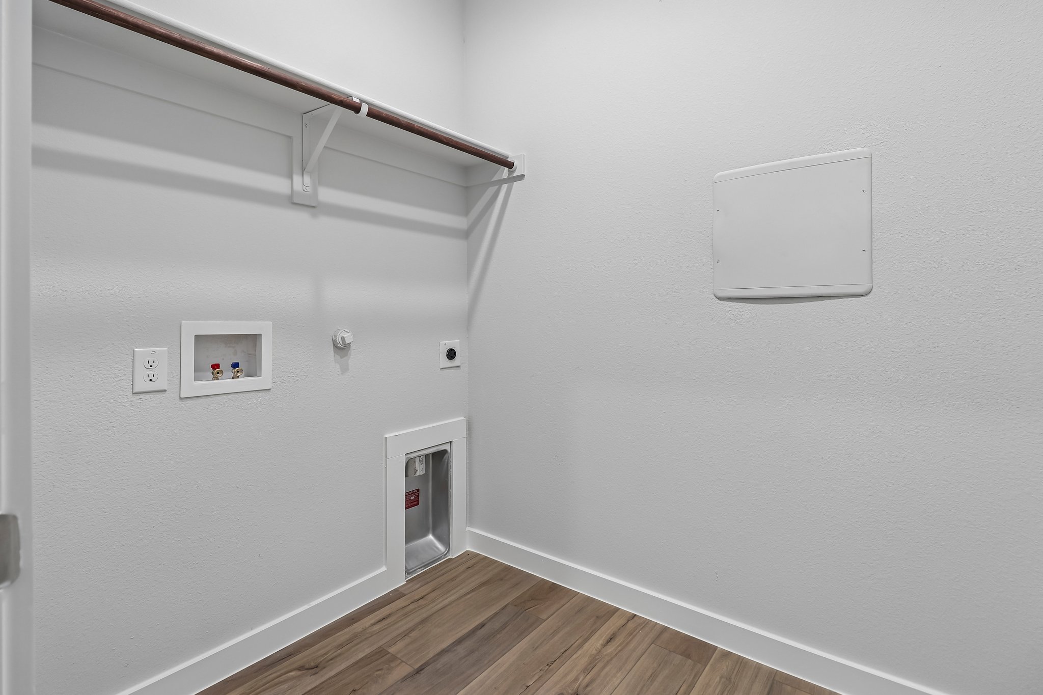 A white wall with a wood floor and a wood floor.