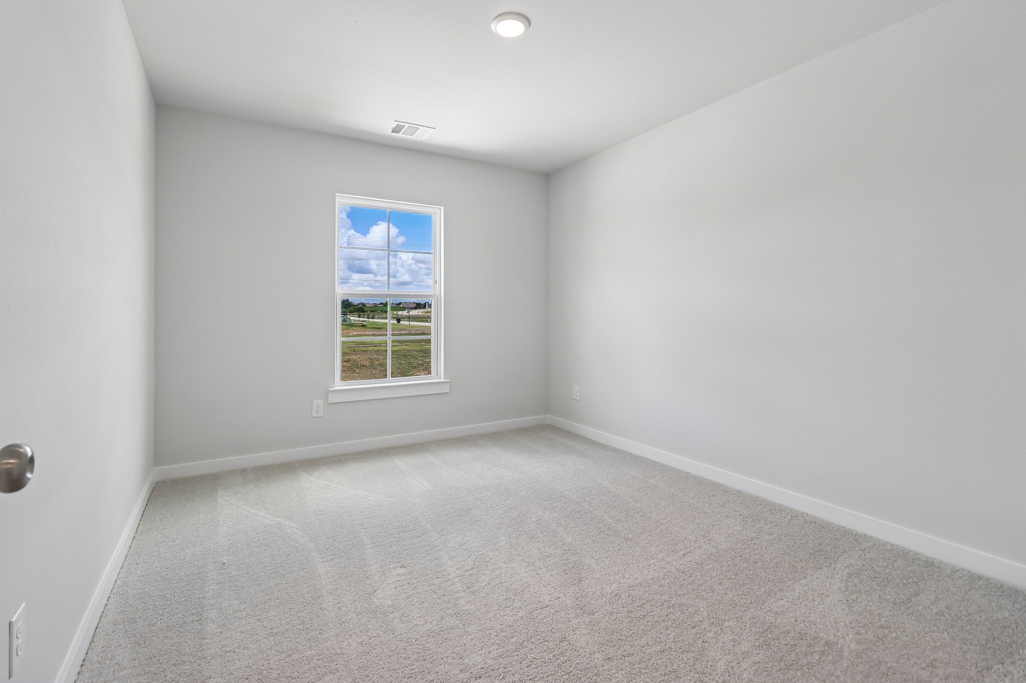 A room with a window and a carpet.