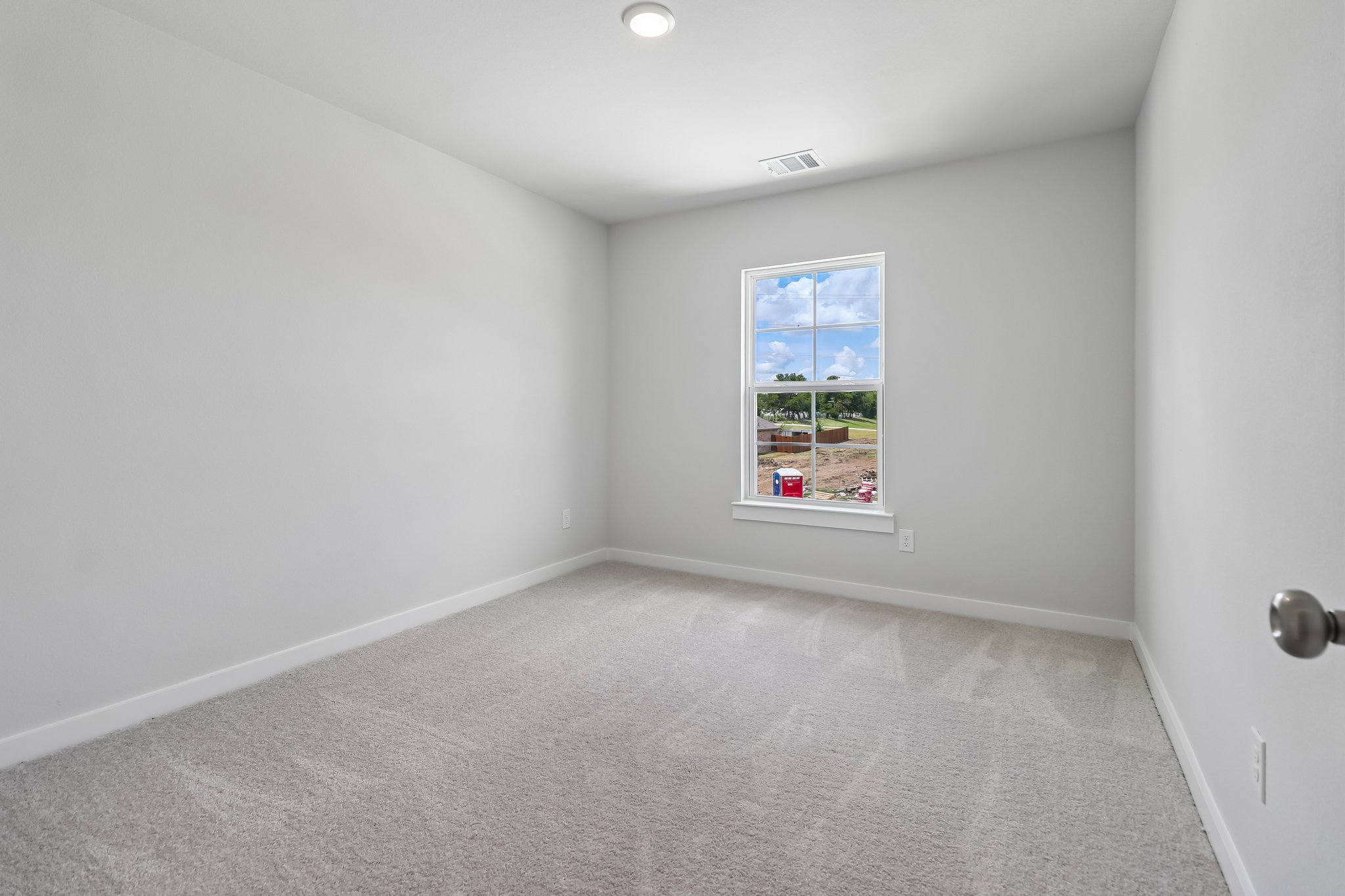 A room with a window and carpet.