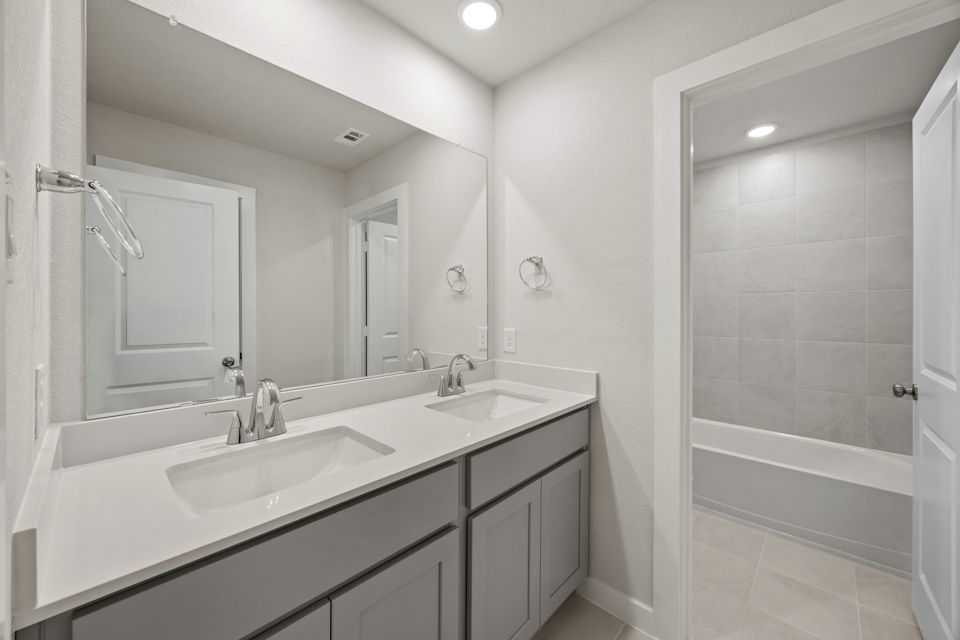 A bathroom with a sink and a shower unit.