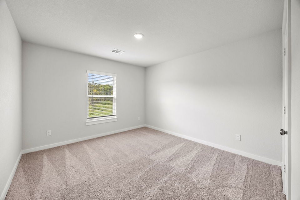 A room with a carpet and a window.