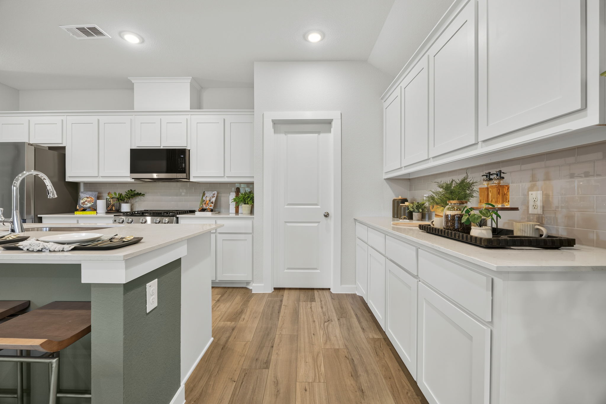 A kitchen with white cabinets.