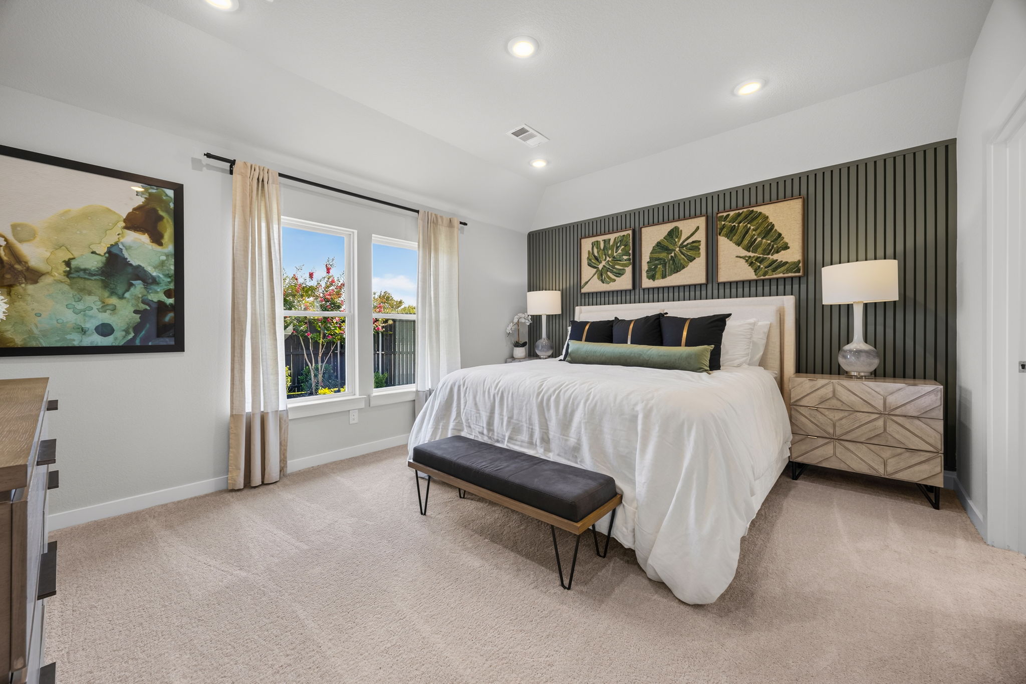 A bedroom with a bed and a bench.
