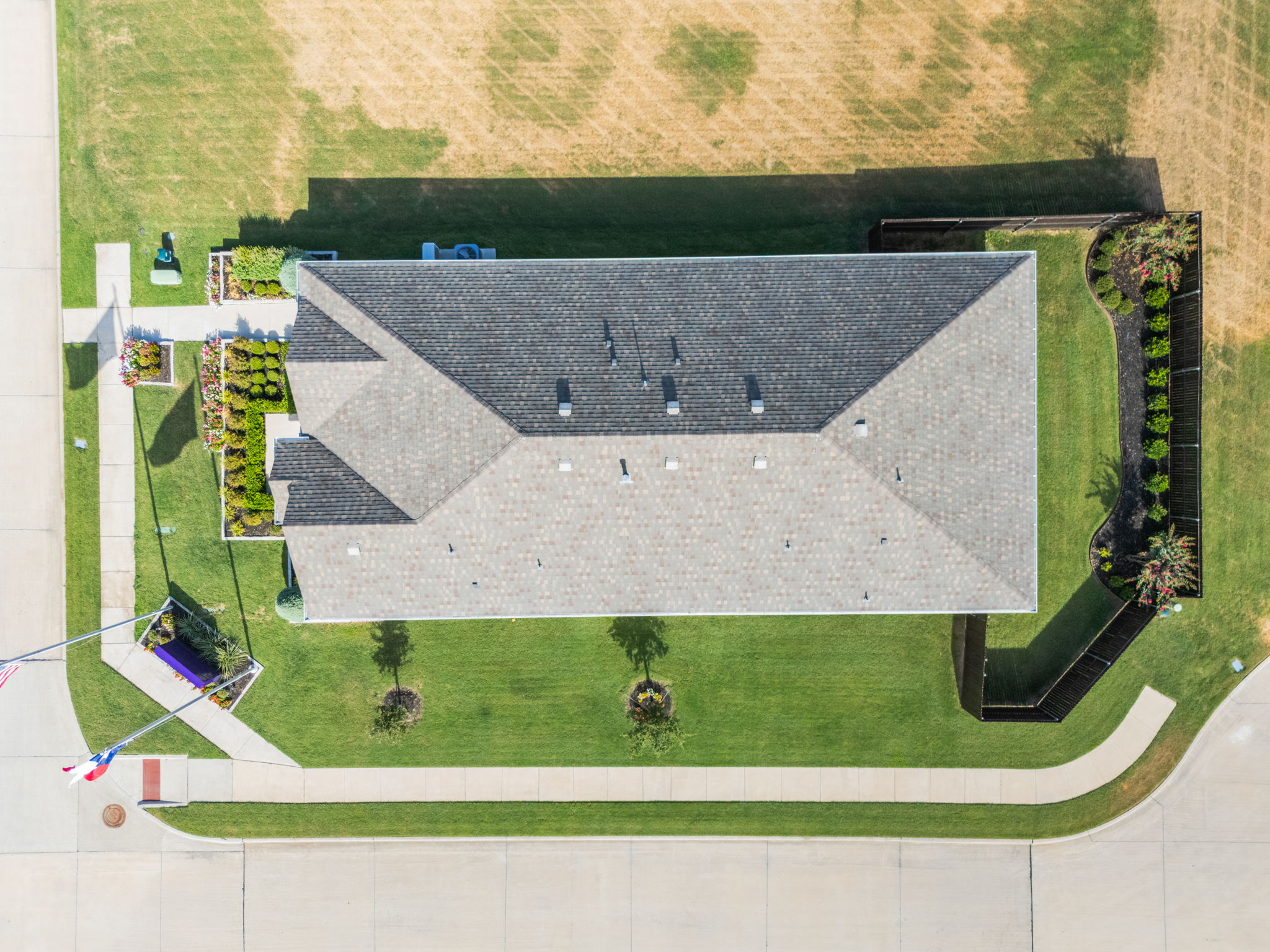 A large building with a grass field.